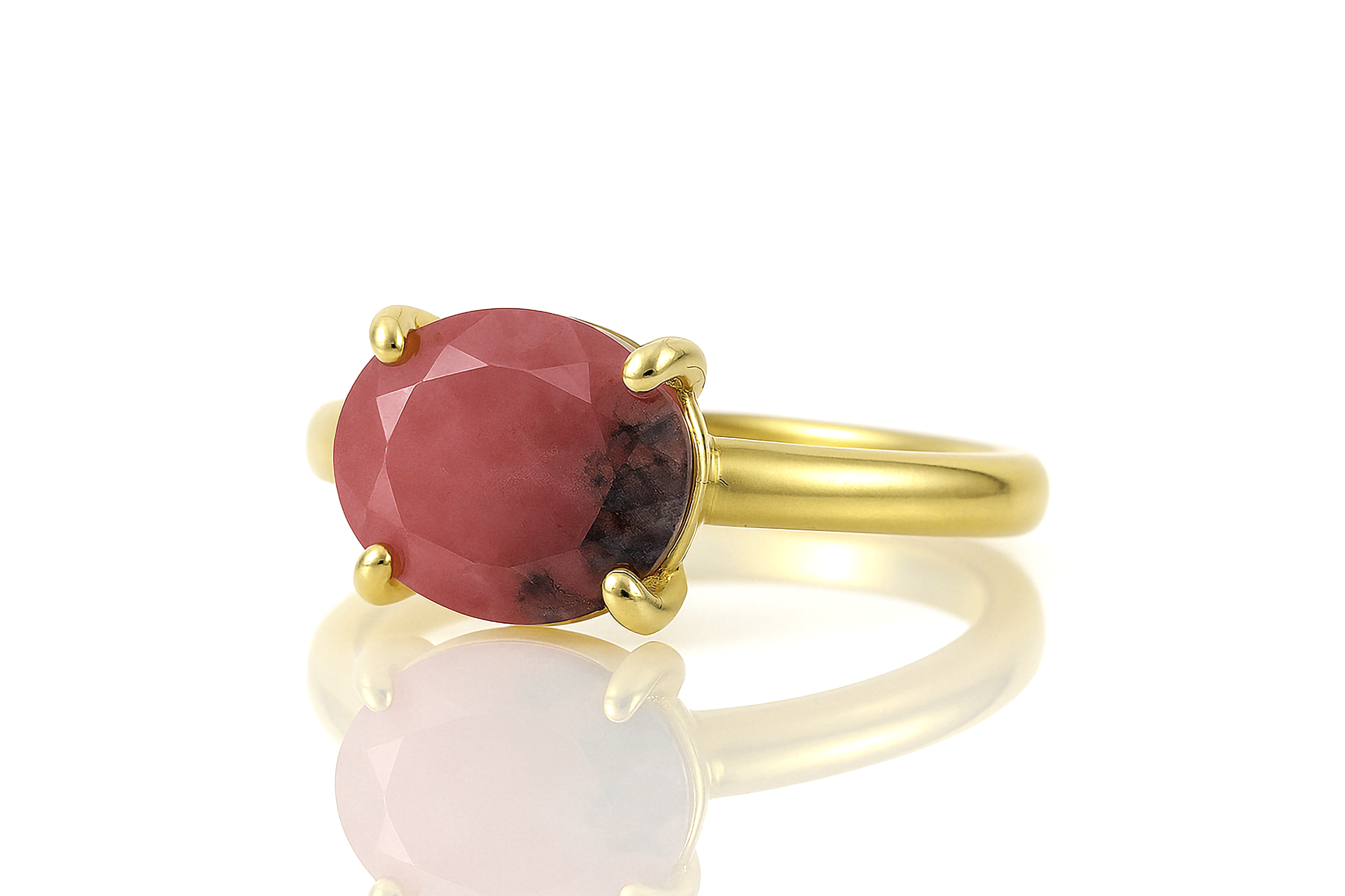 a gold ring with a large red stone
