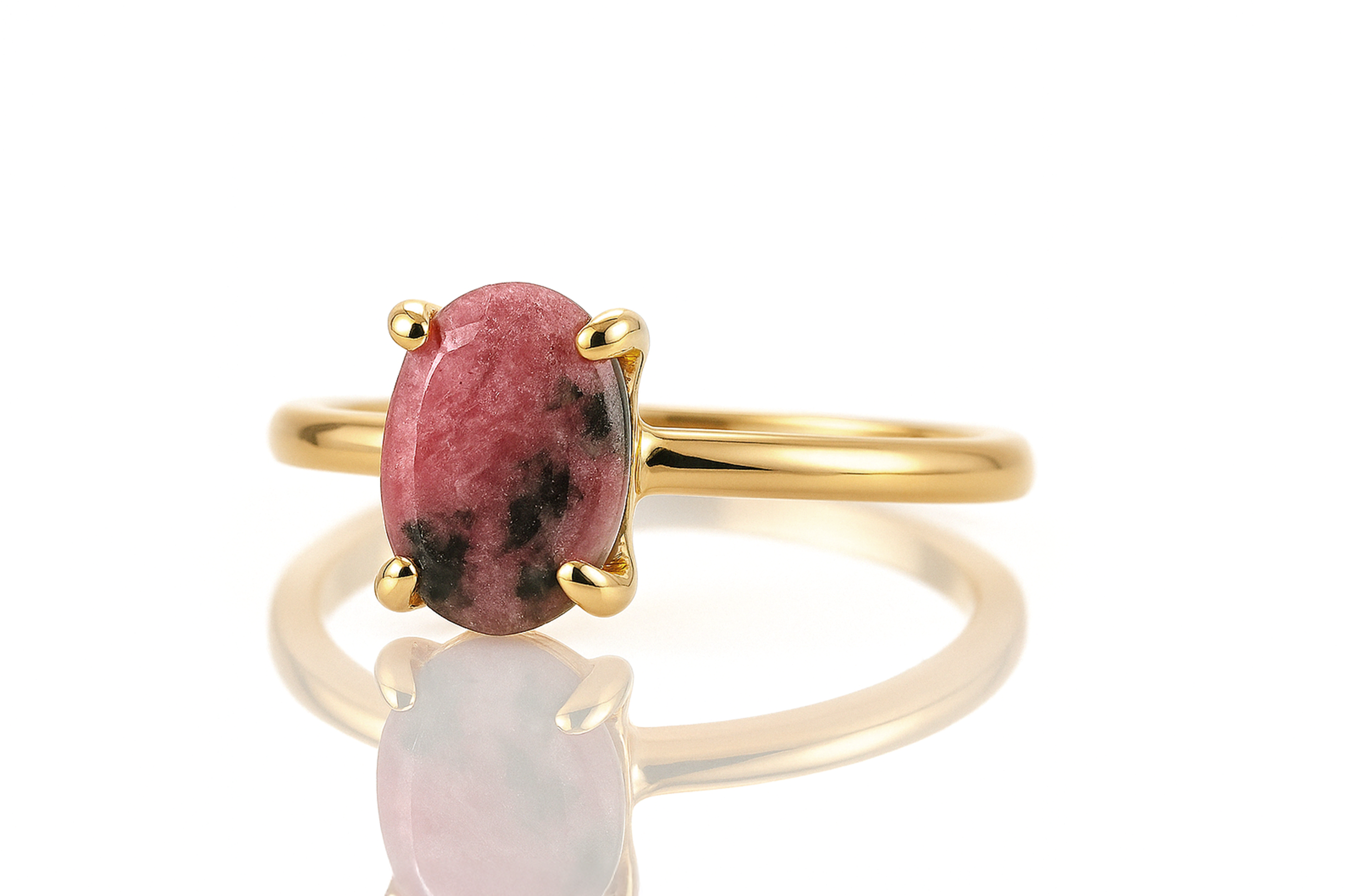 a gold ring with a pink stone on it