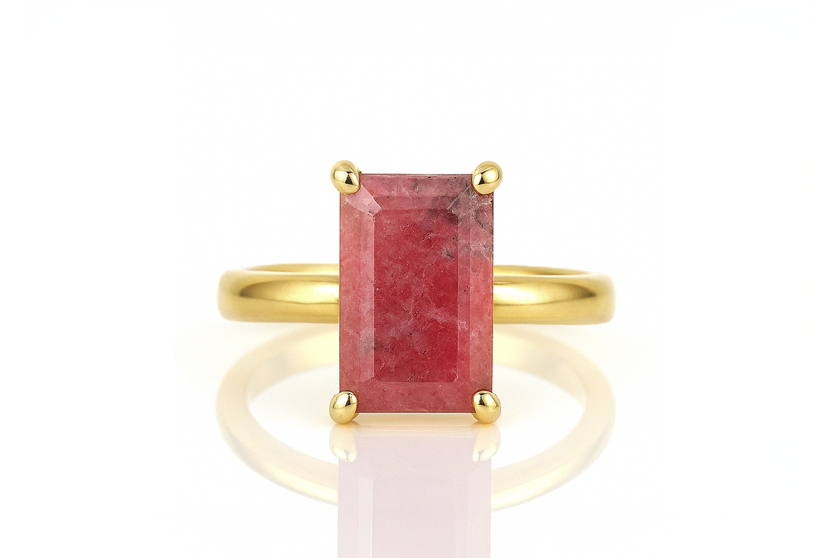 a gold ring with a red stone on it