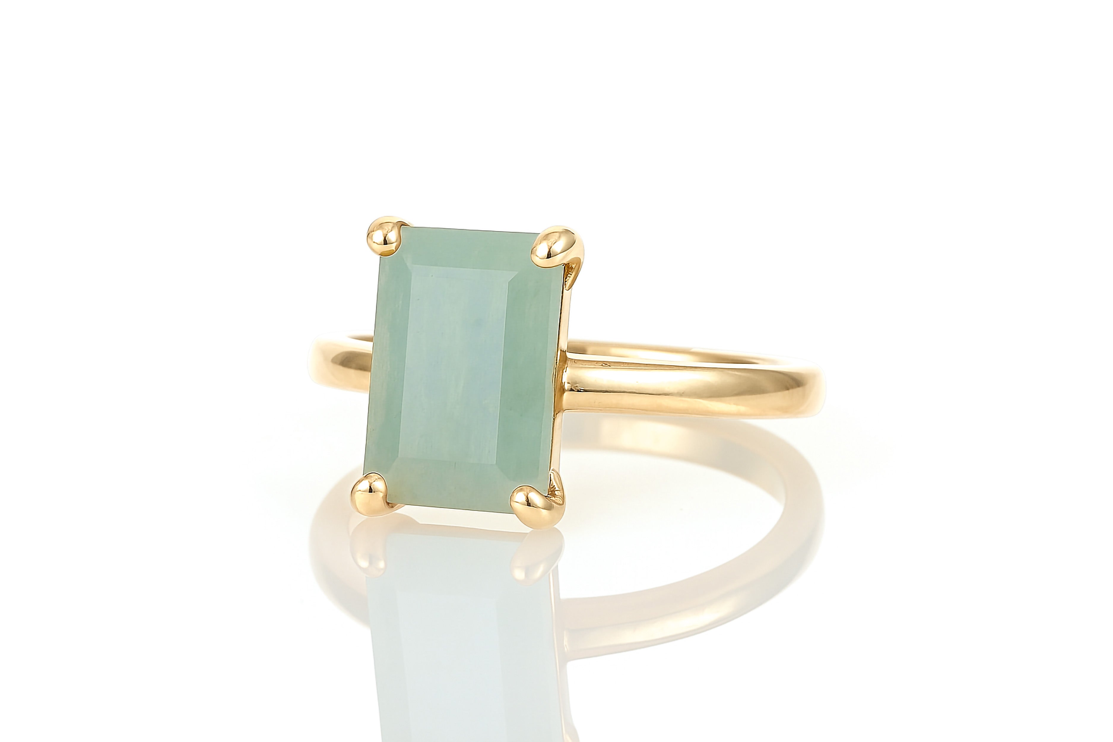 a gold ring with a green stone on it