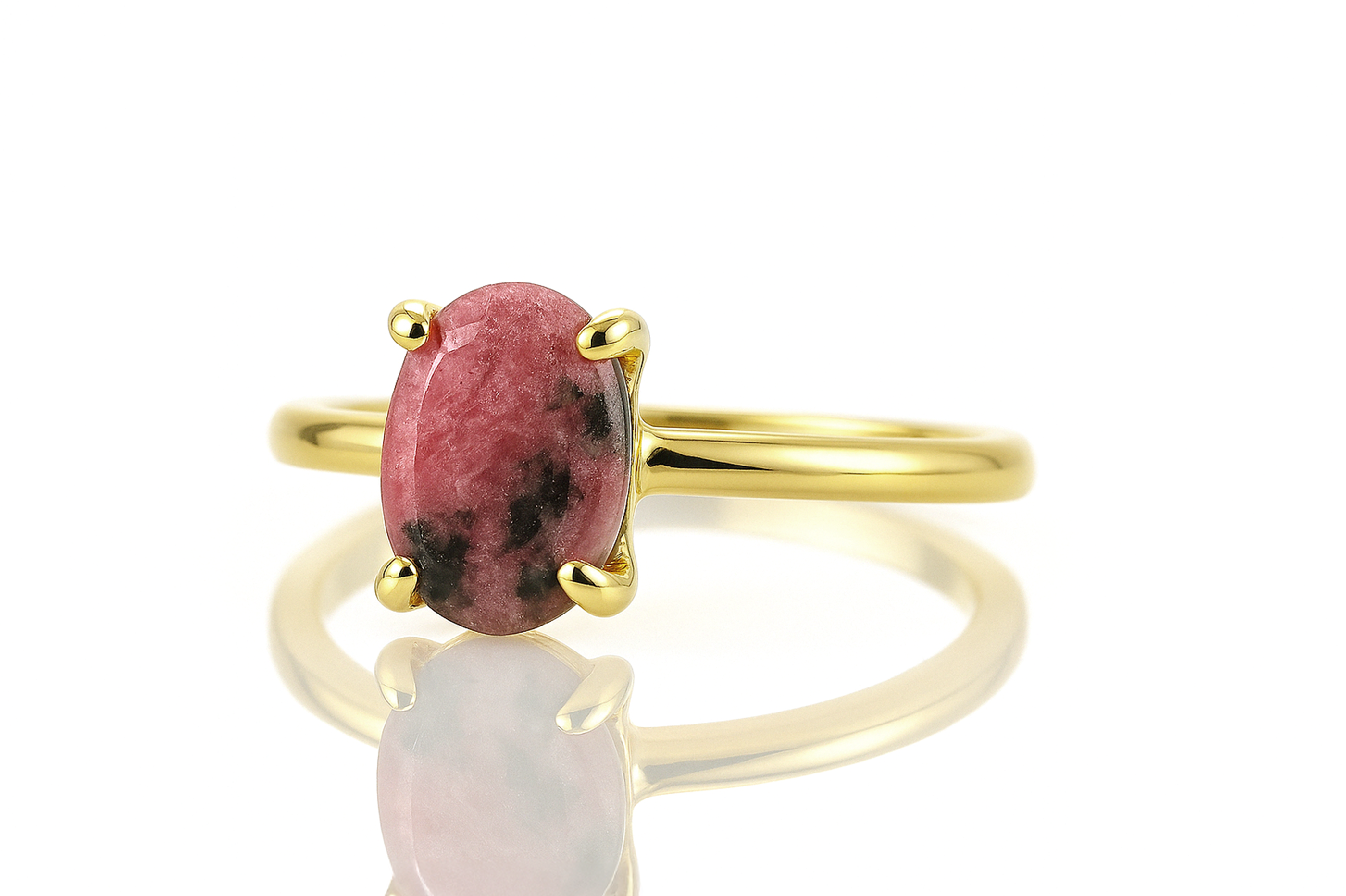 a gold ring with a pink stone on it