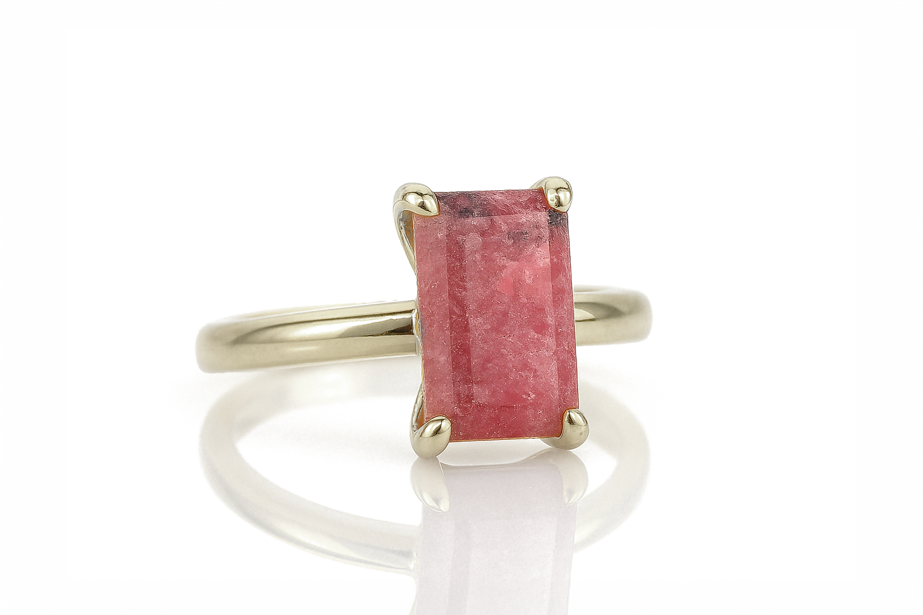 a gold ring with a red stone in it