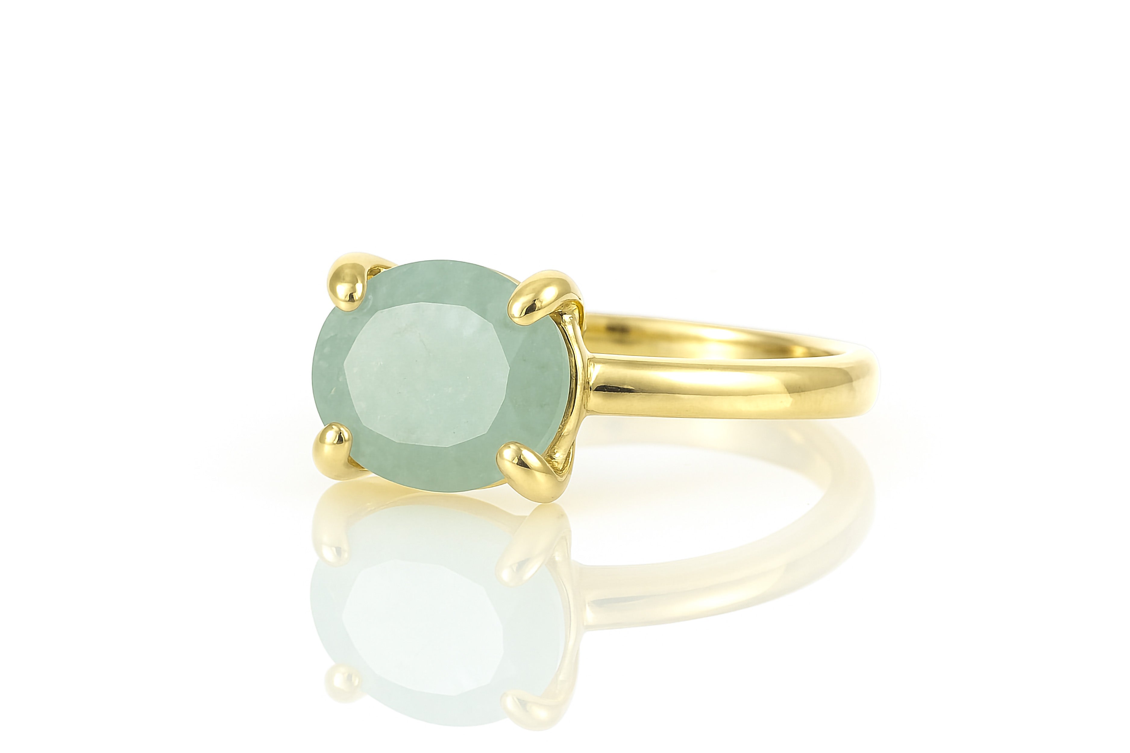 a gold ring with a green stone on it