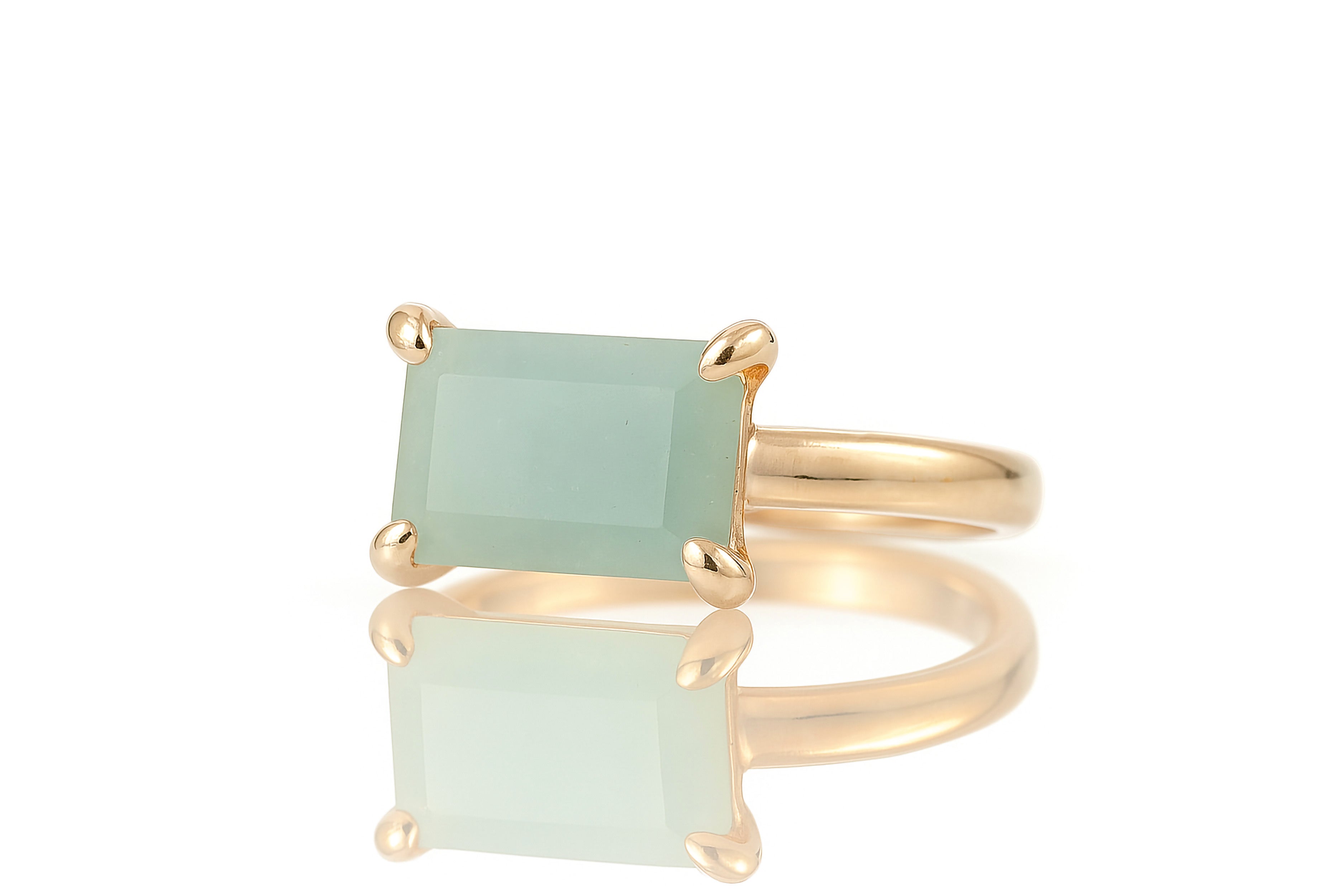 a gold ring with an aqua green stone