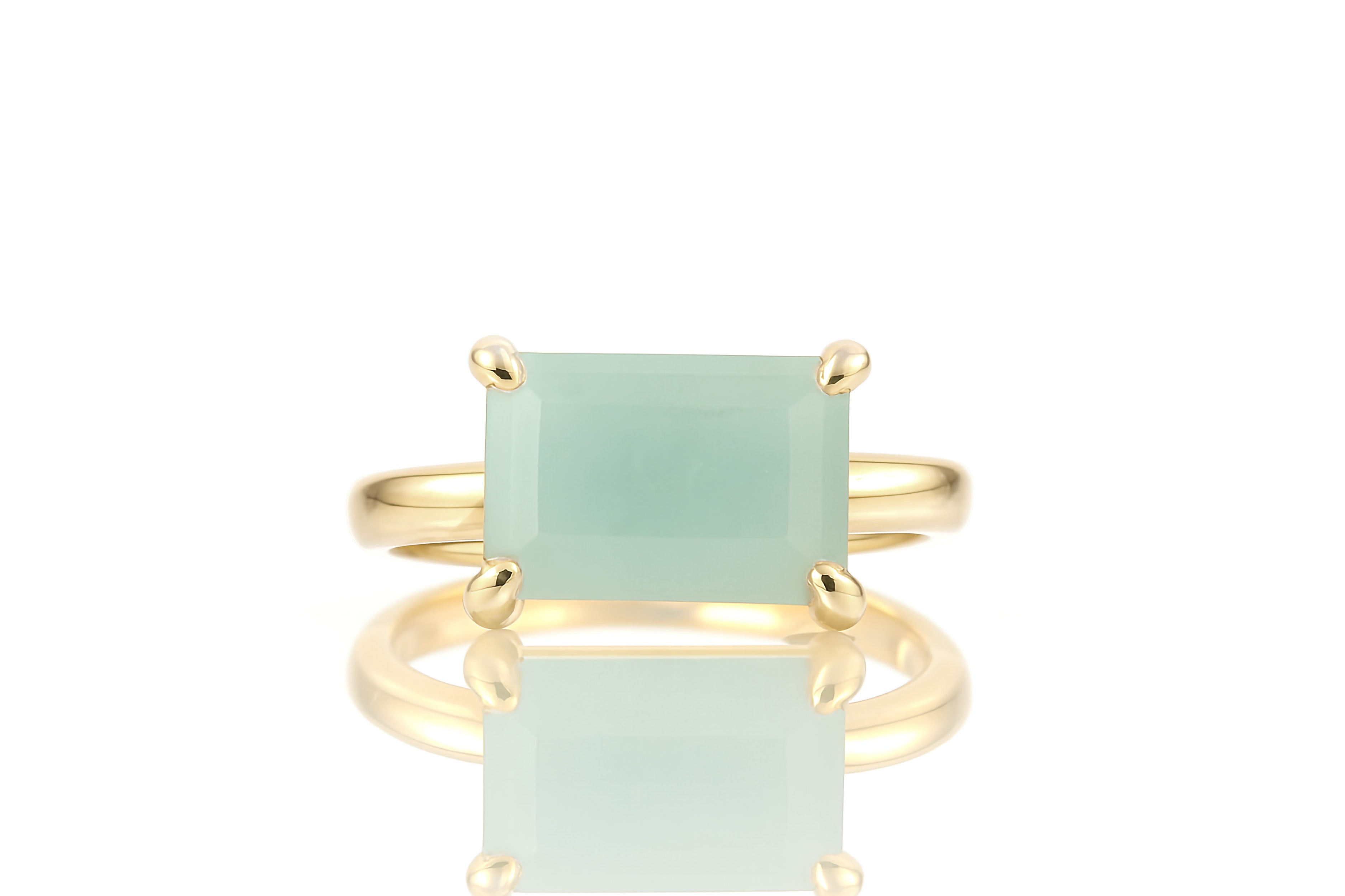 a gold ring with a green stone on it