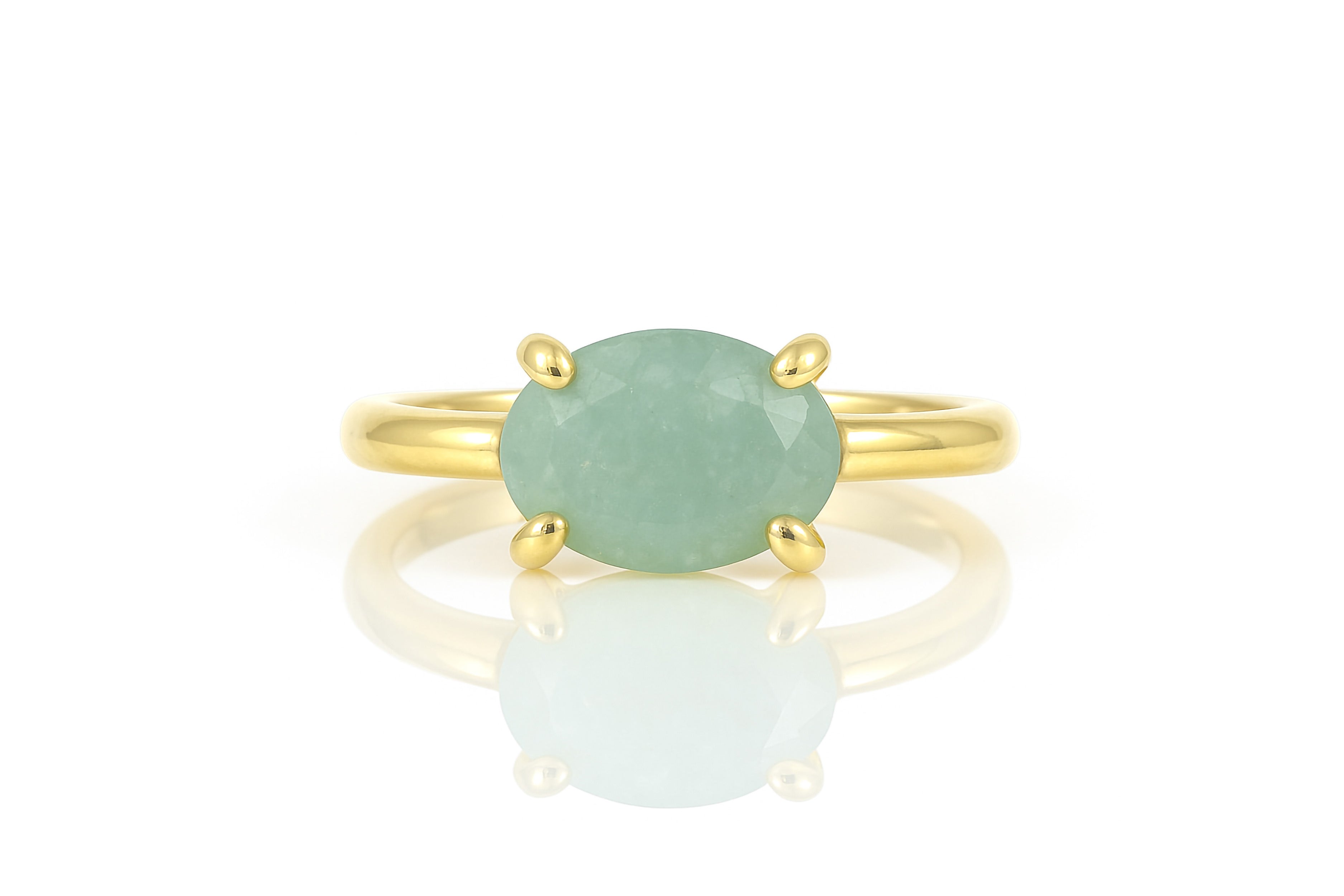 a gold ring with a green stone on it