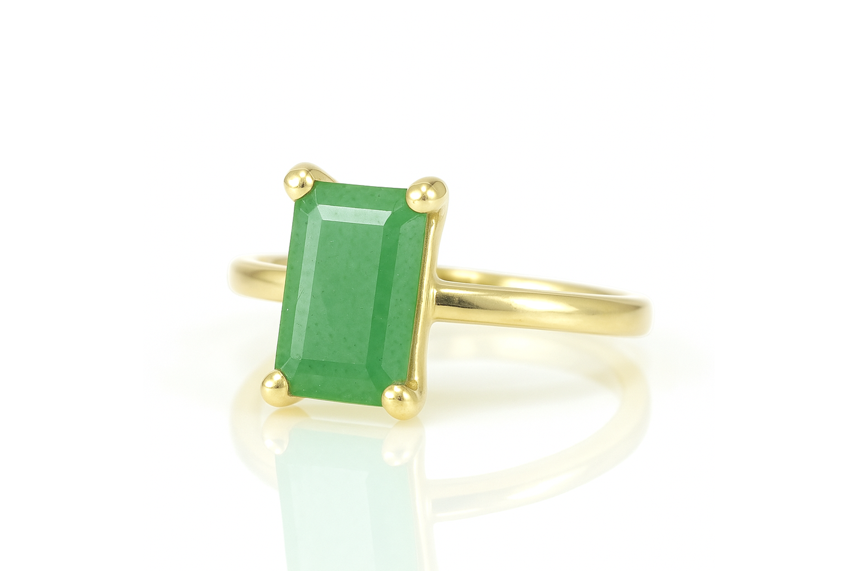 a gold ring with an emerald stone