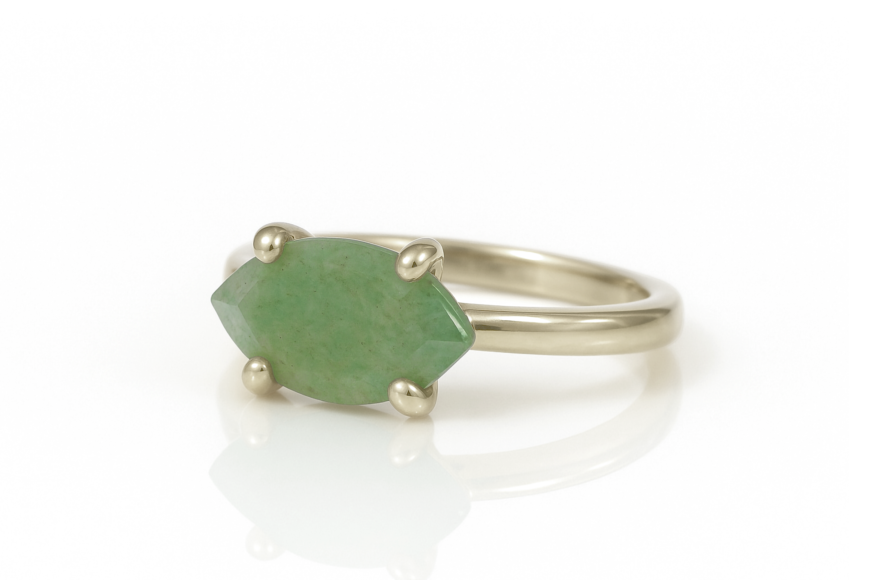 a close up of a ring with a green stone