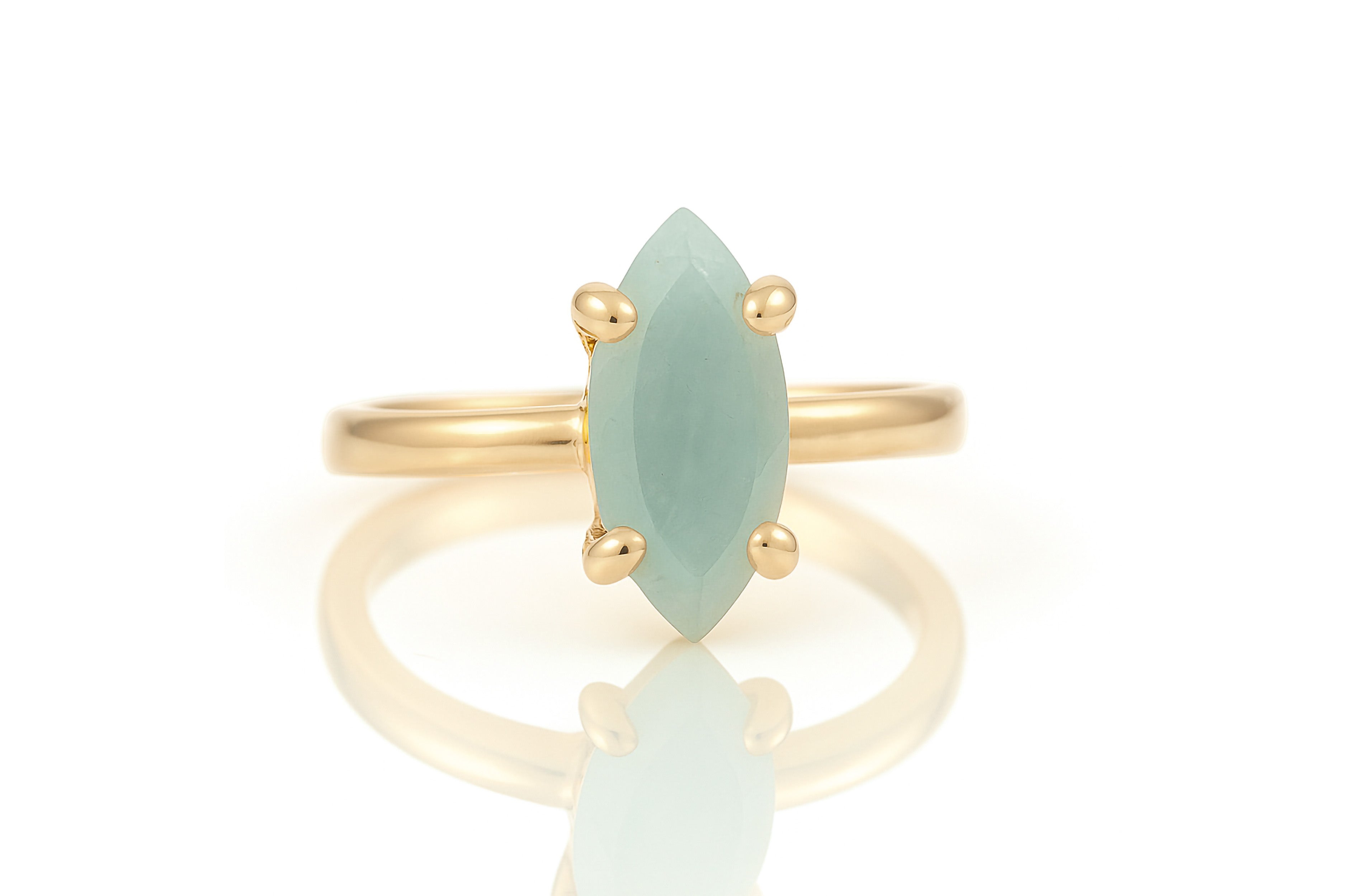 a gold ring with a green stone on it