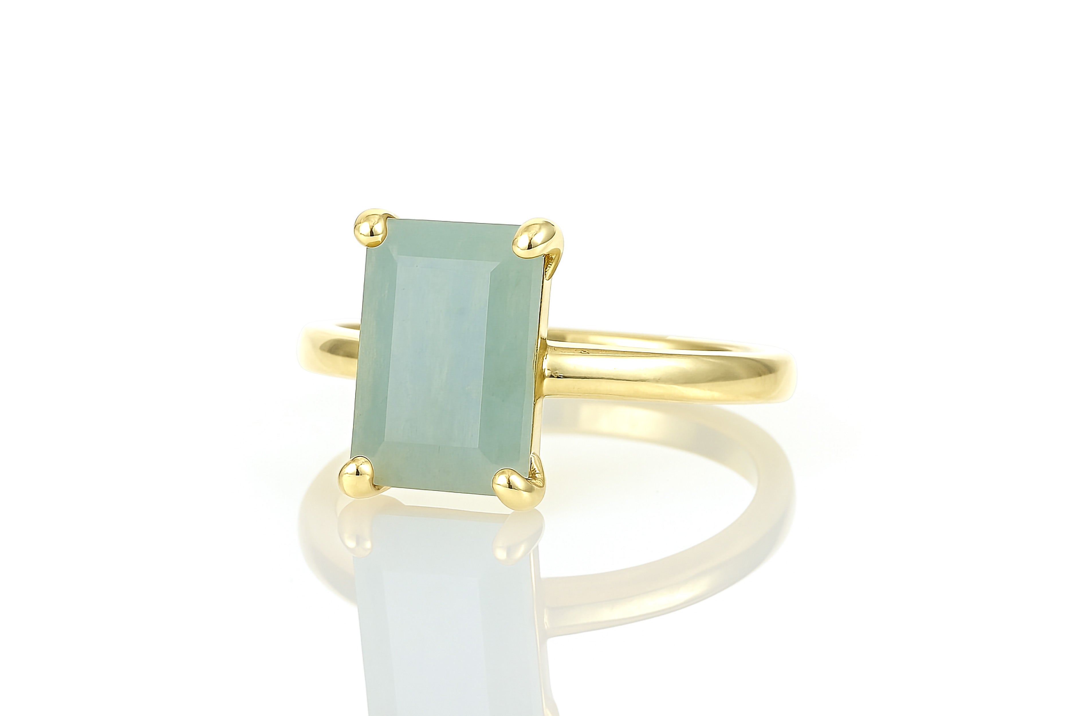 a gold ring with a green stone on it