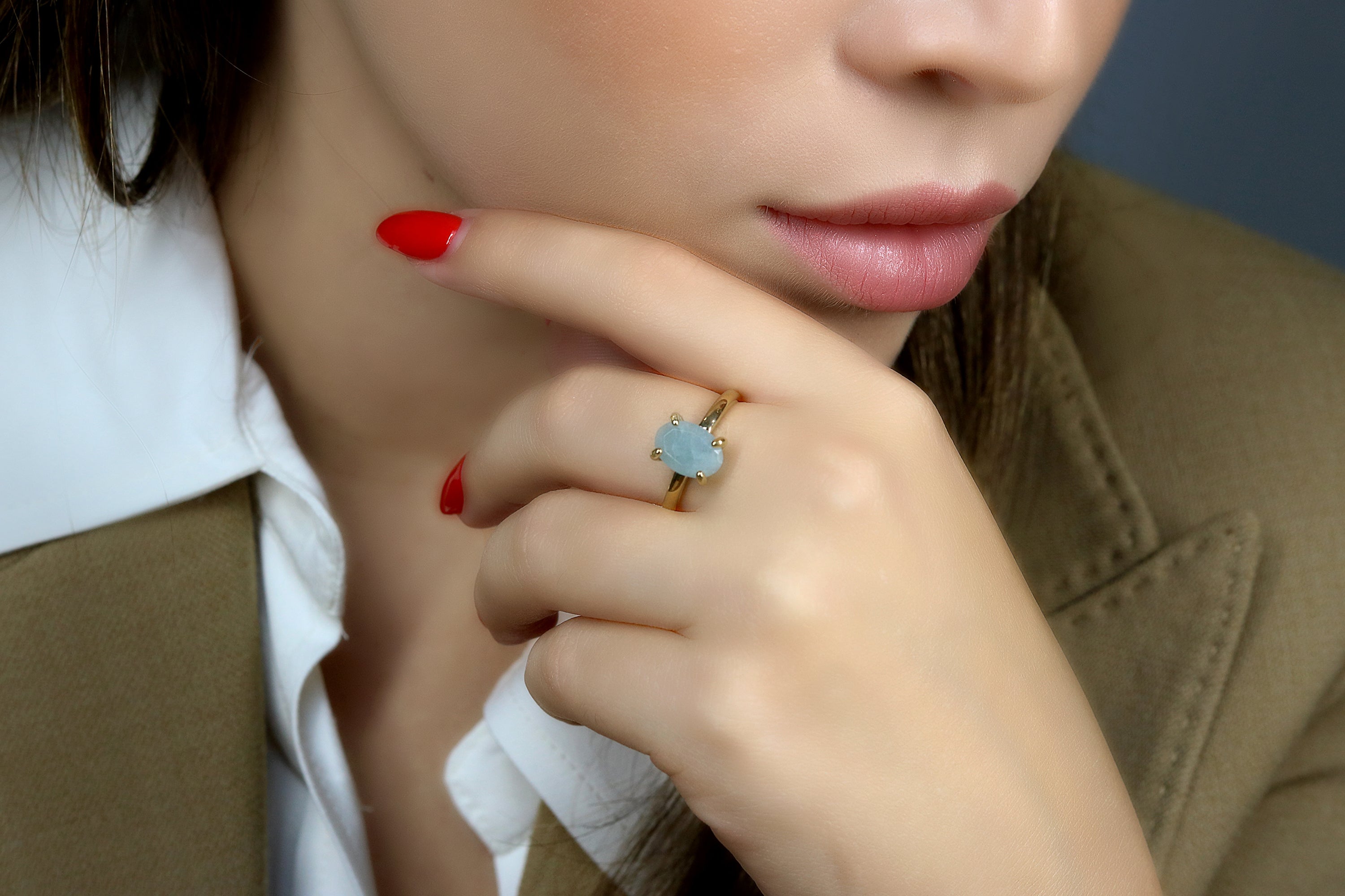 a woman wearing a ring with a blue flower on it