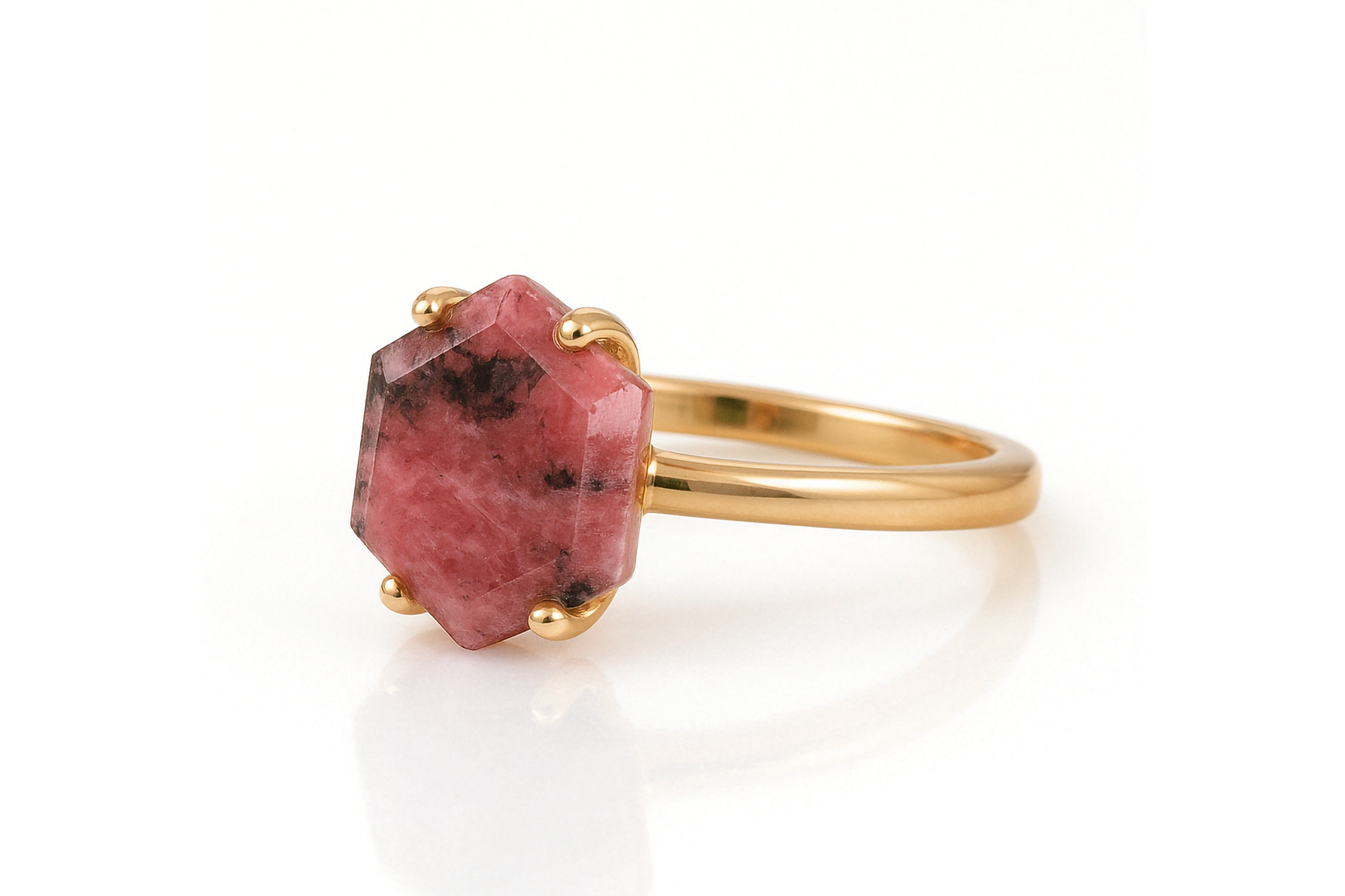 a gold ring with a pink stone on it