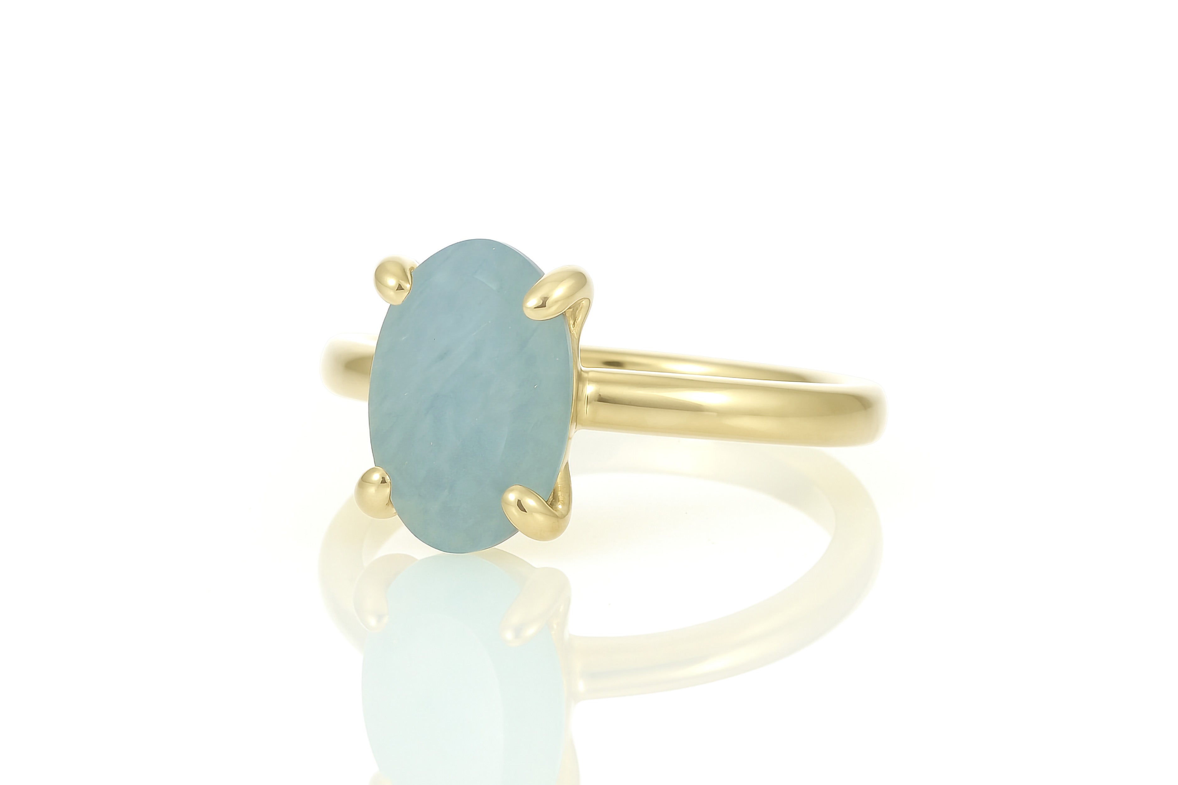 a yellow gold ring with a blue stone