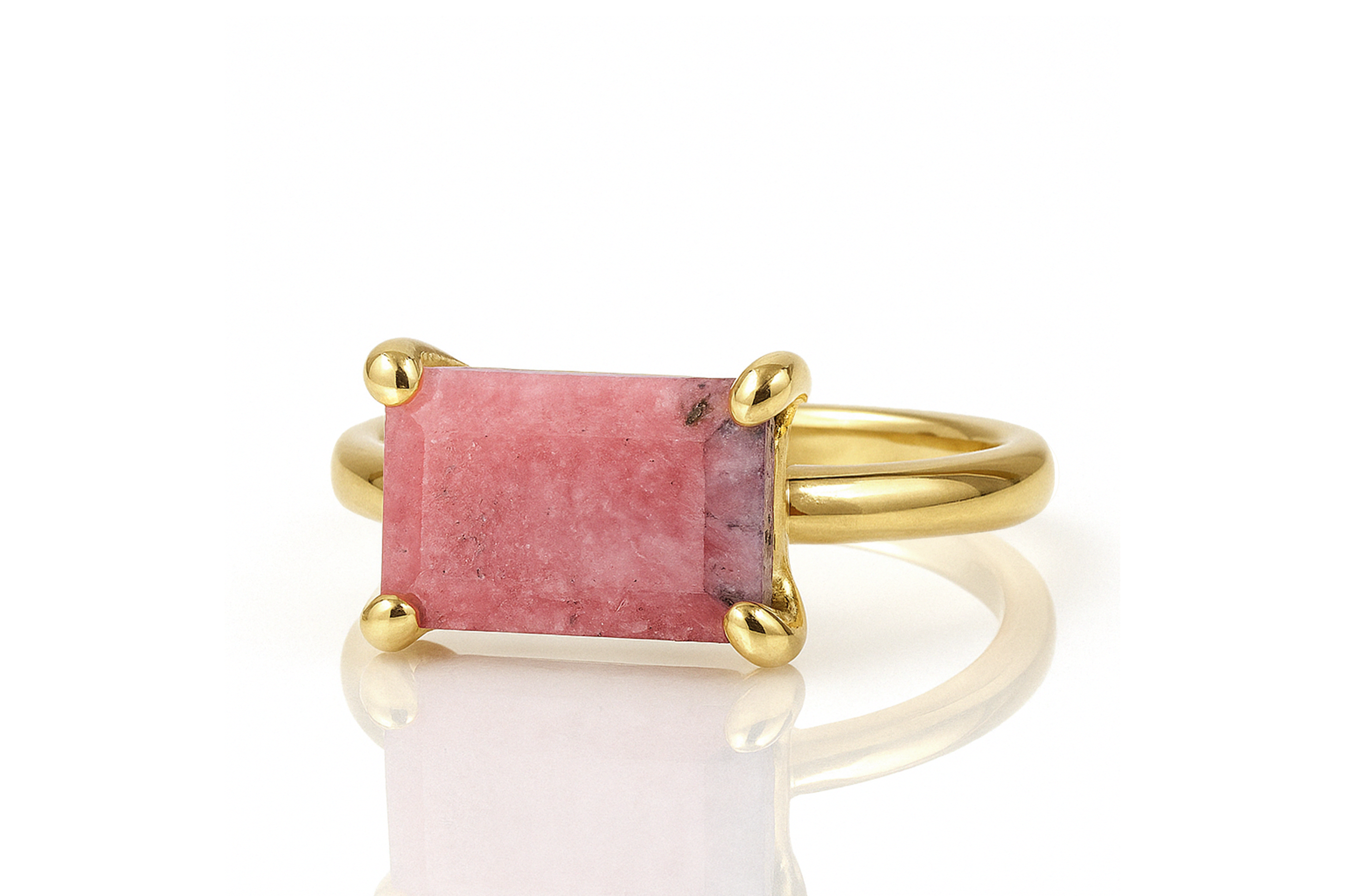 a gold ring with a pink stone on it