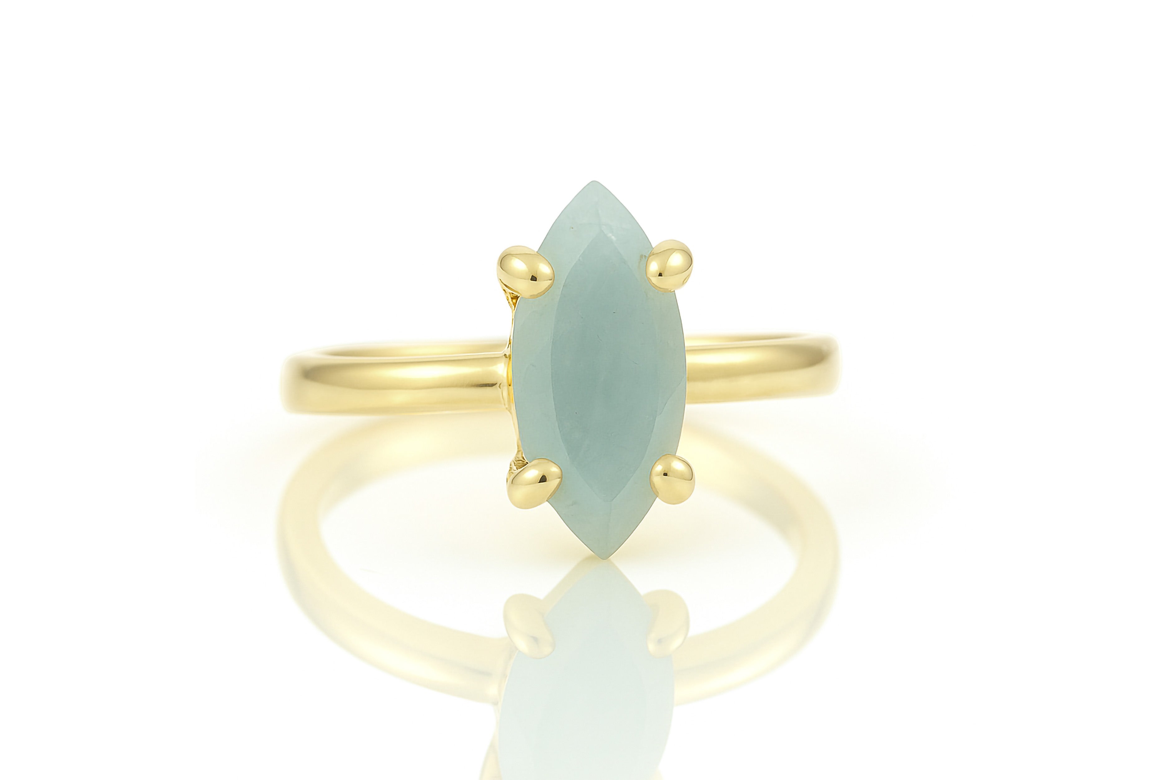 a yellow gold ring with a green stone