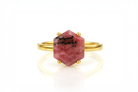 a gold ring with a red stone on it