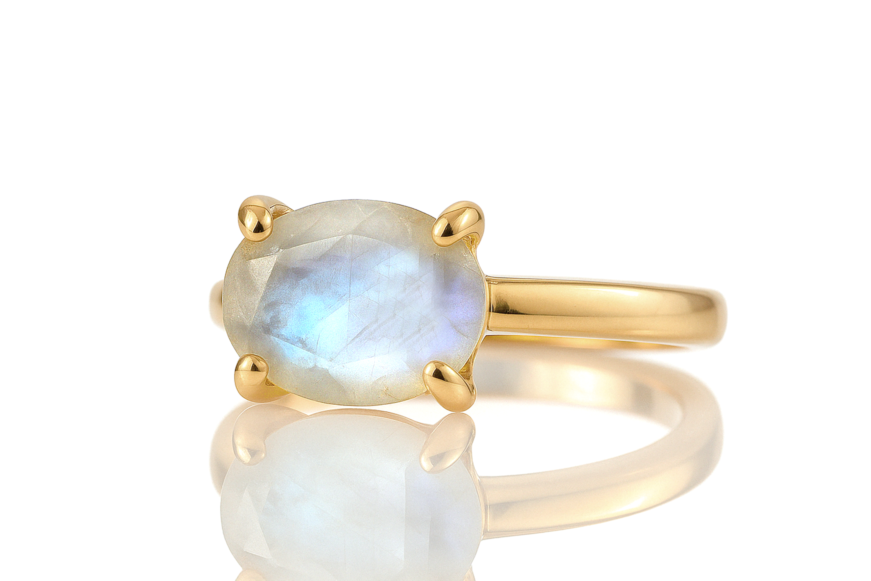 a yellow gold ring with a rainbow colored stone