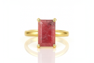 a gold ring with a red stone on it