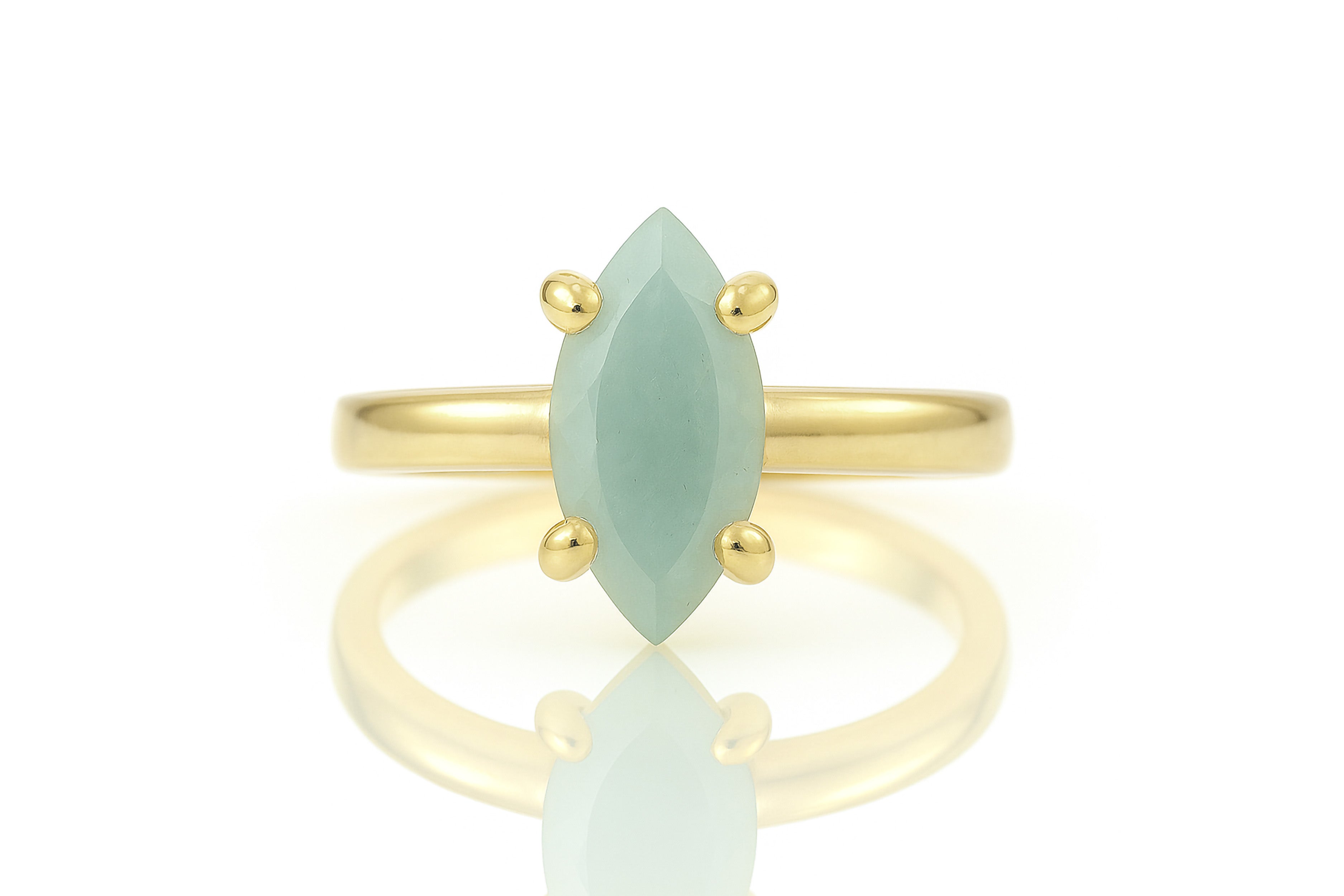 a yellow gold ring with a green stone