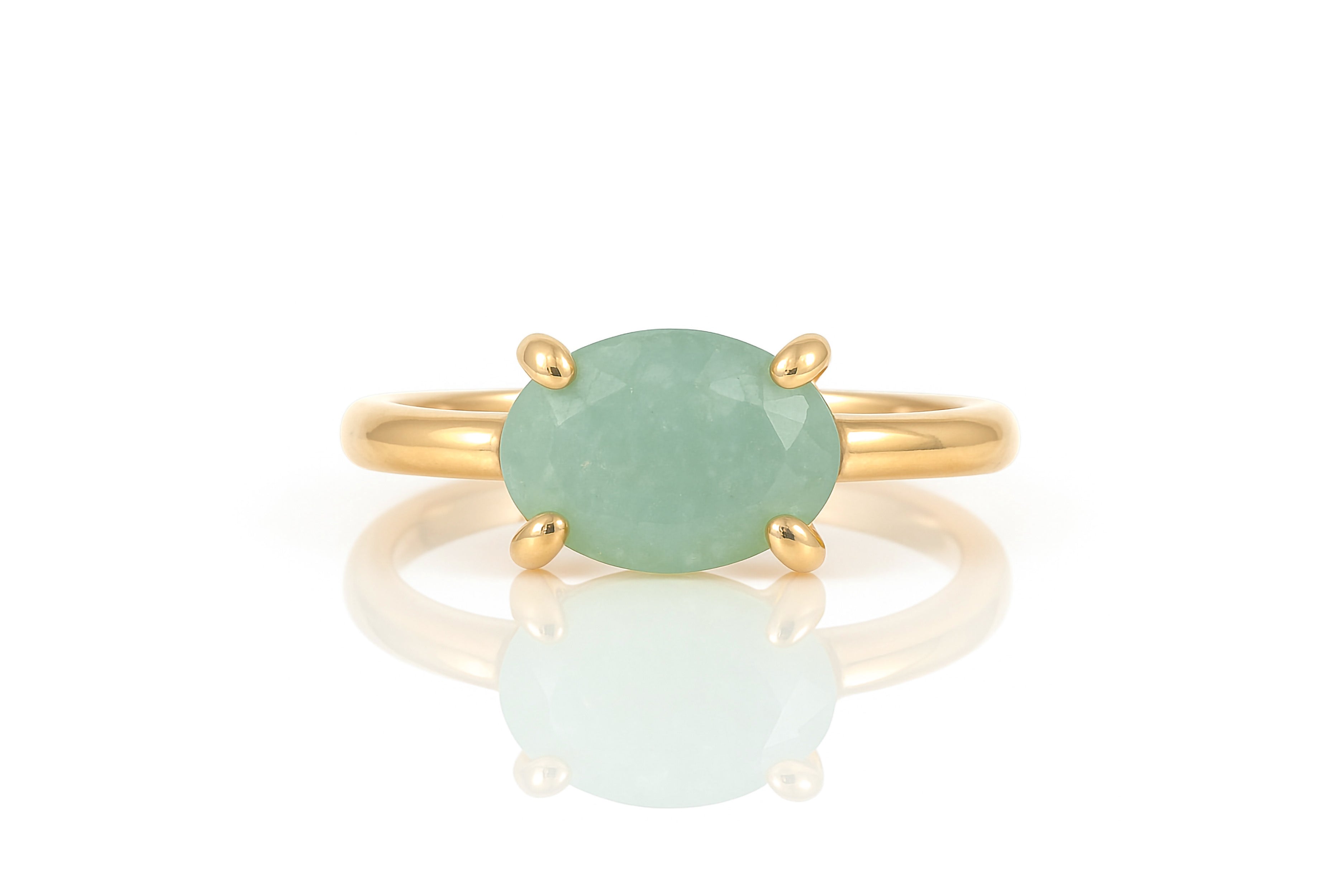 a gold ring with a green stone on it