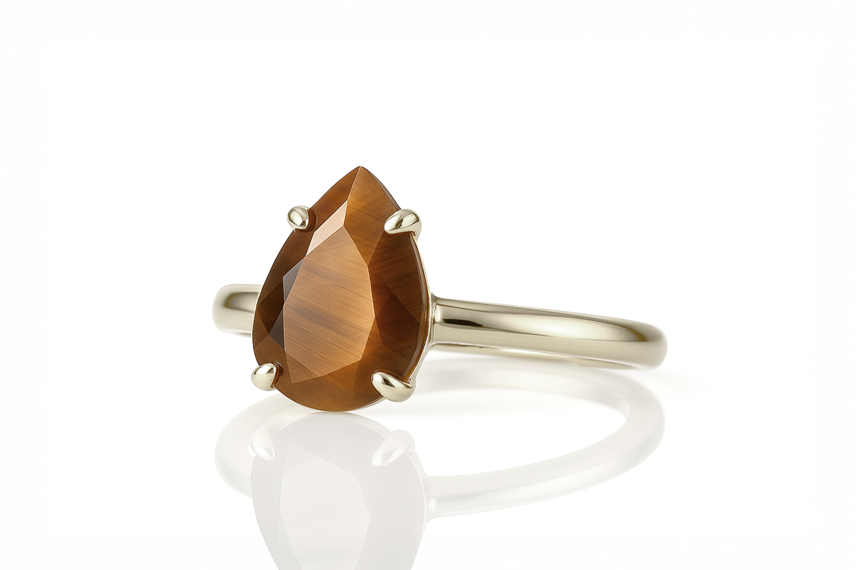 a yellow gold ring with a pear shaped stone