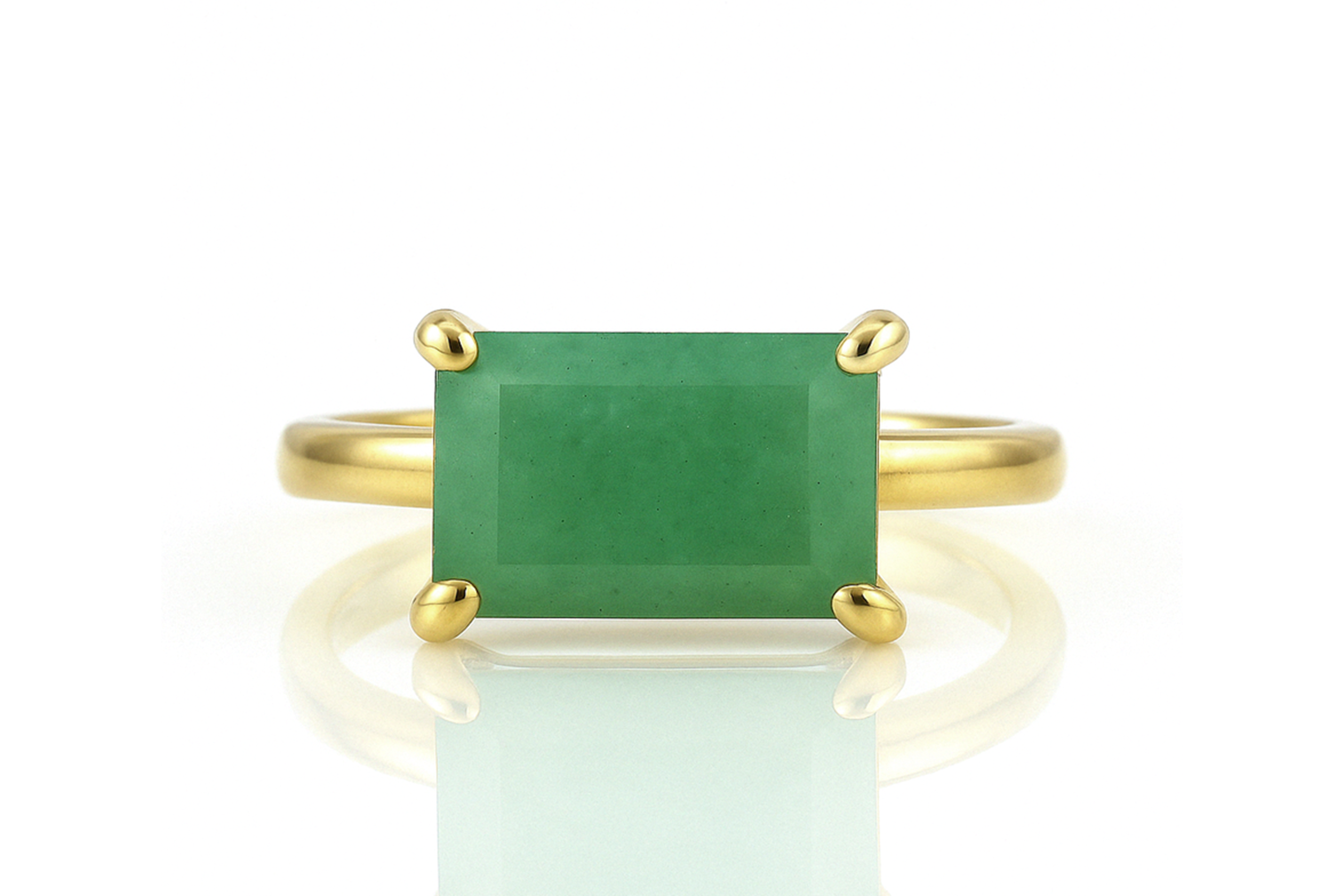 a gold ring with a green stone on it