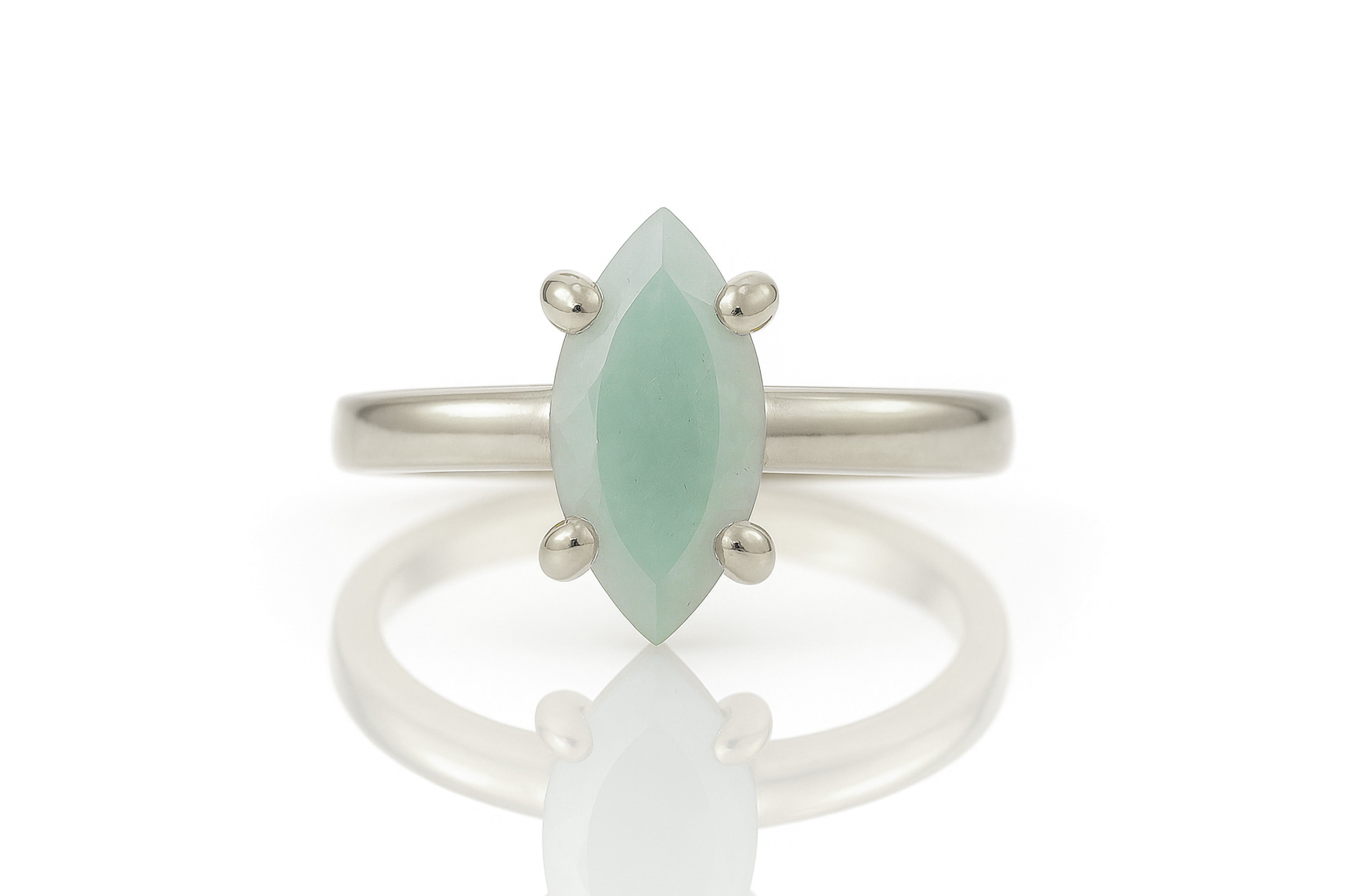 a white gold ring with a green stone