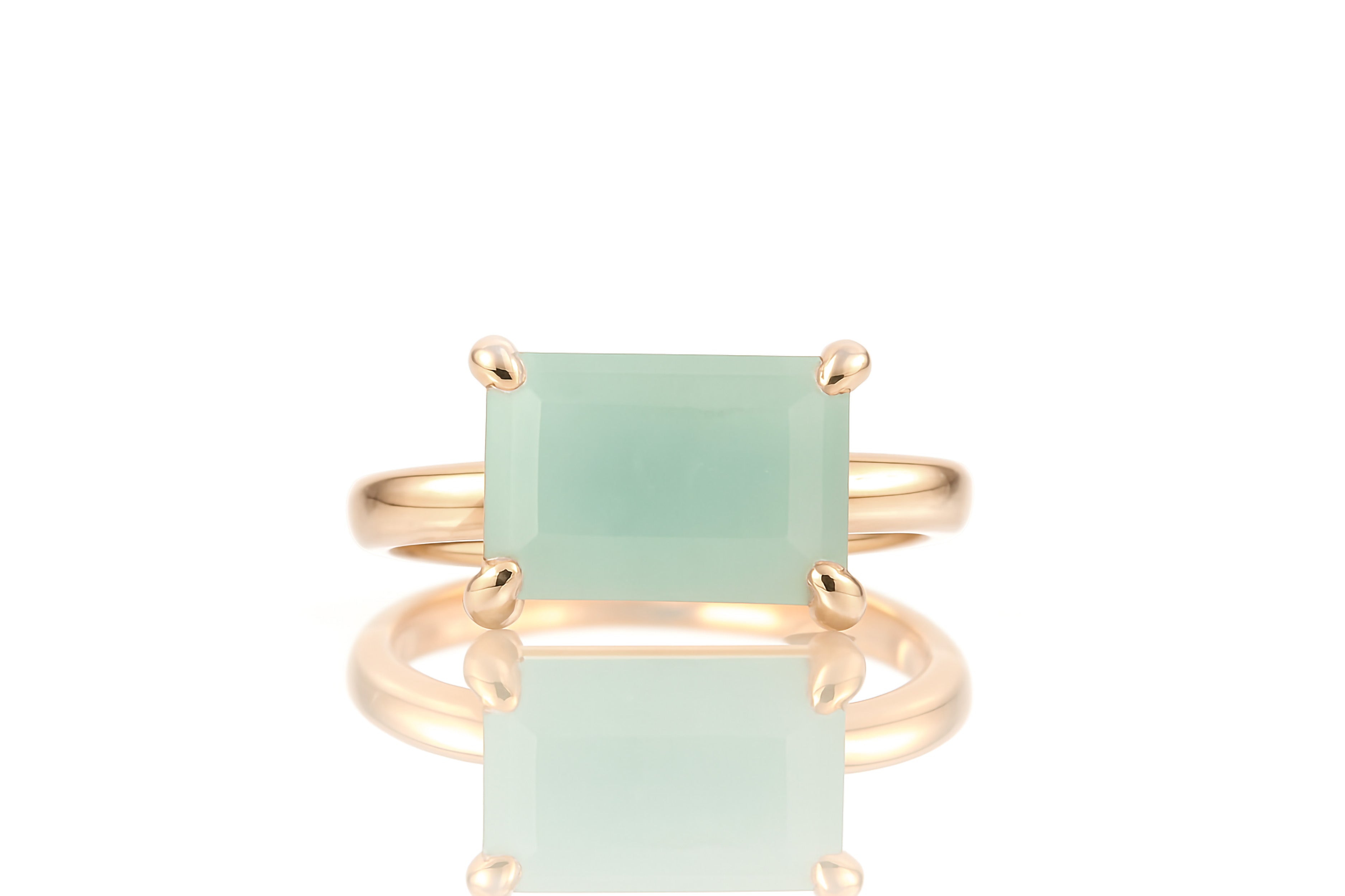 a gold ring with a green stone on it