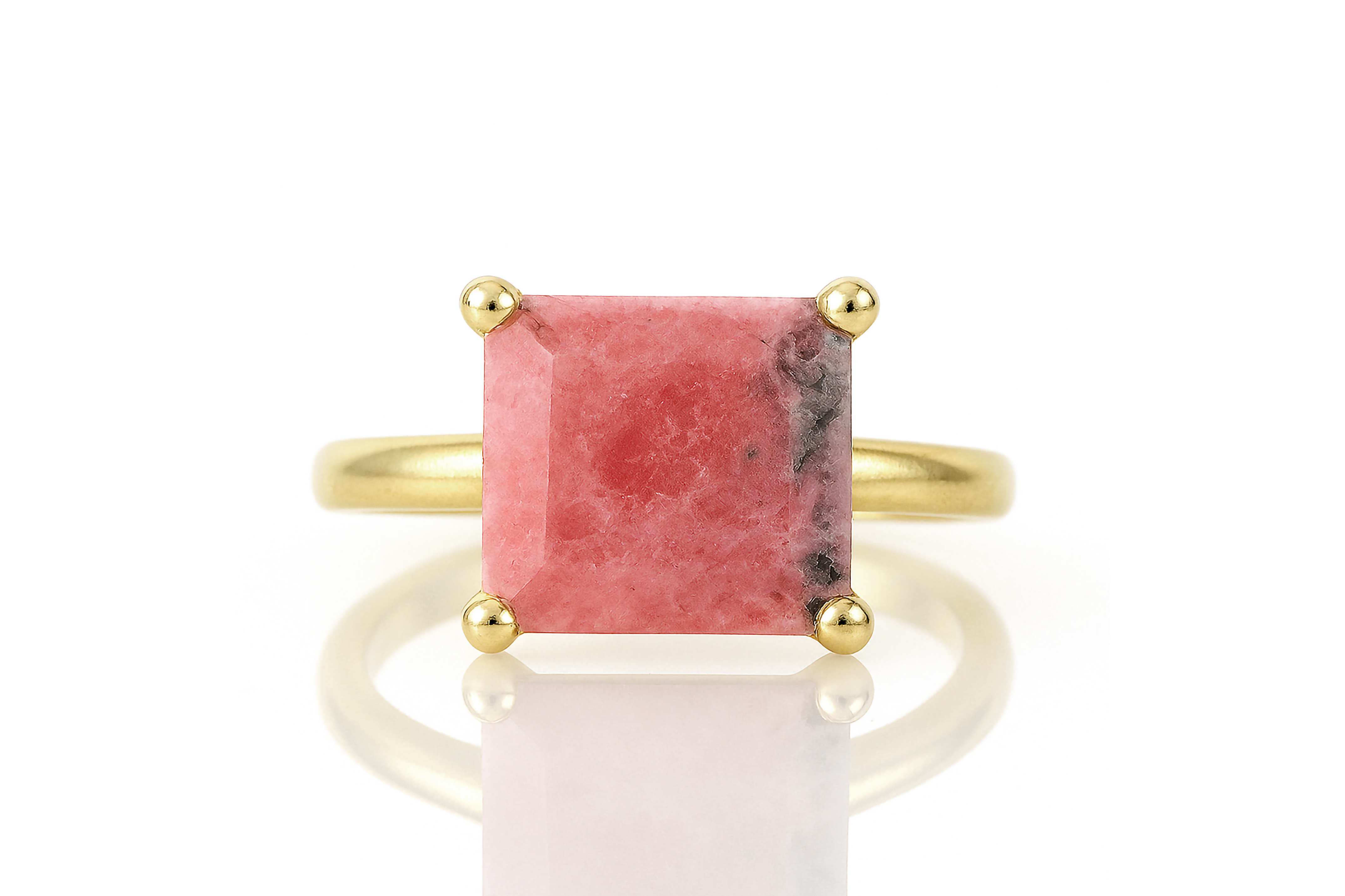 a gold ring with a pink stone on it