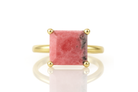 a gold ring with a pink stone on it