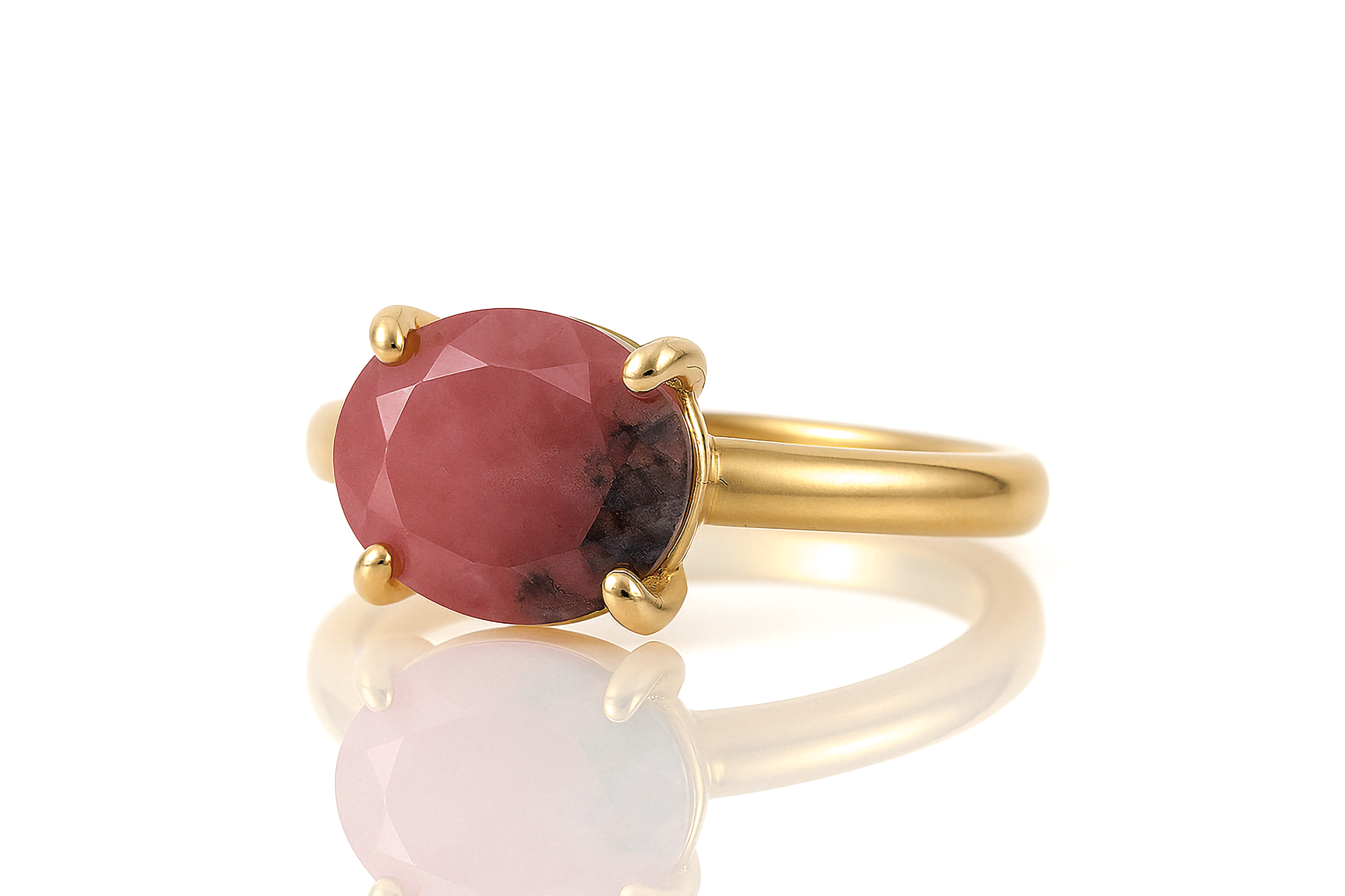 a gold ring with a large red stone