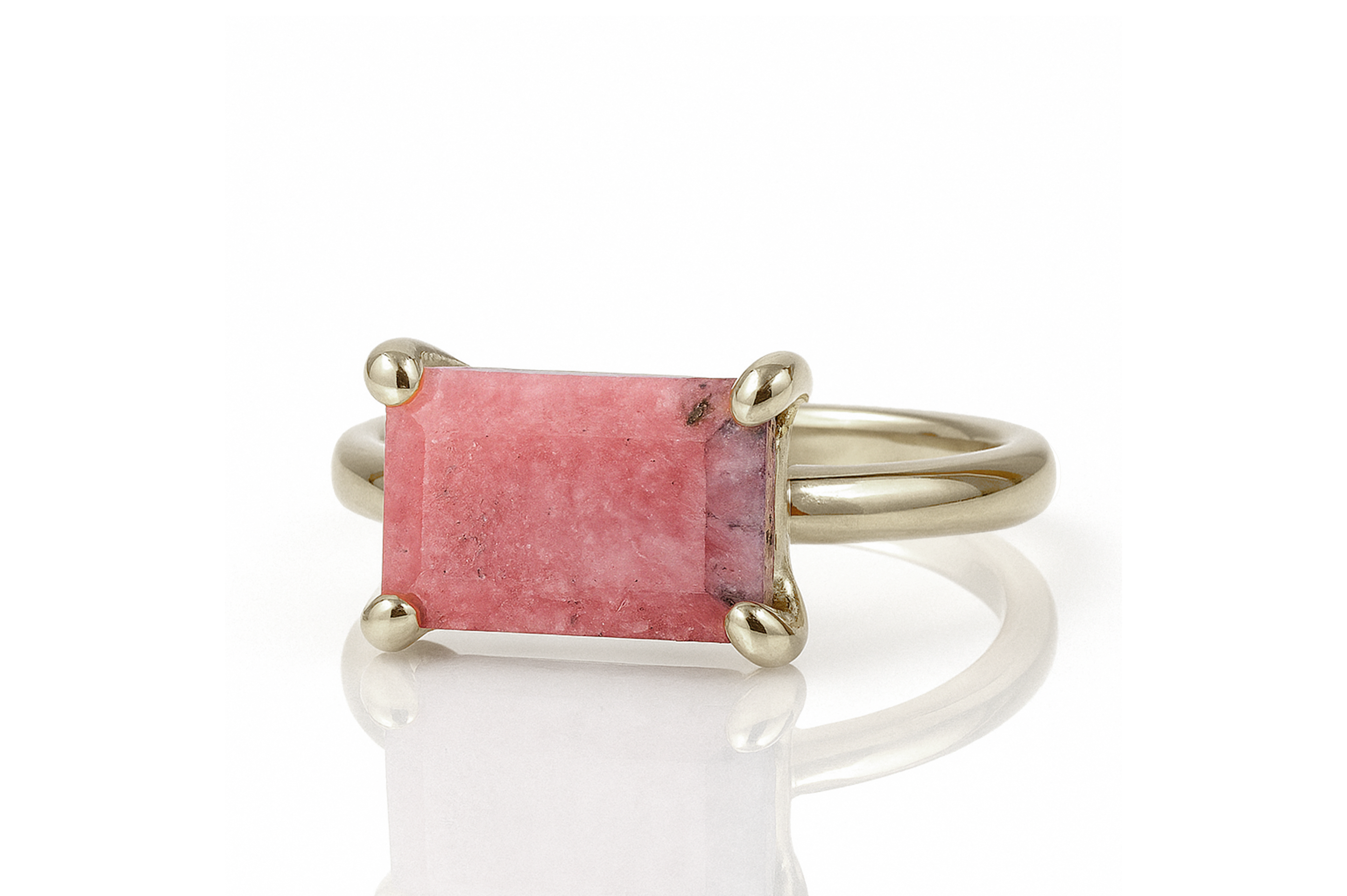 a close up of a ring with a pink stone