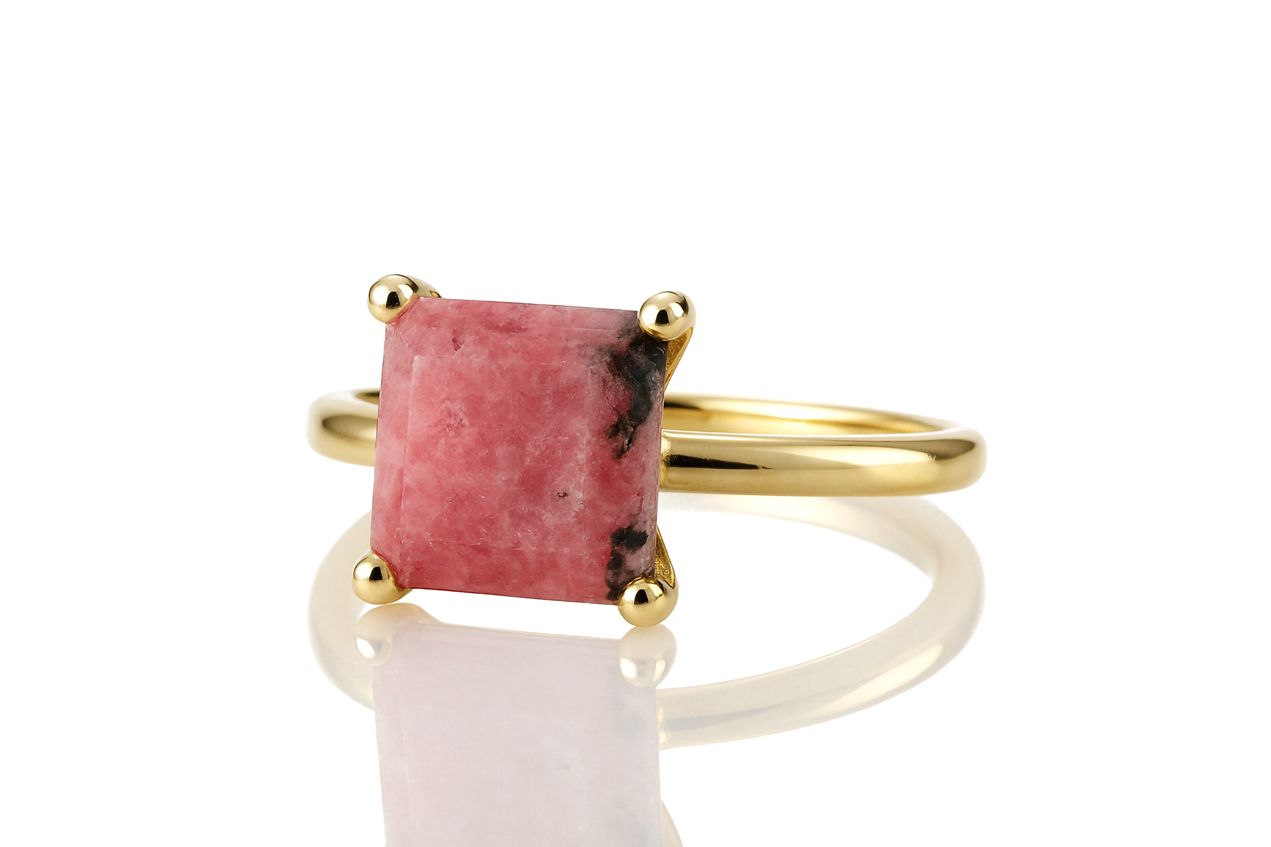a gold ring with a pink stone in it