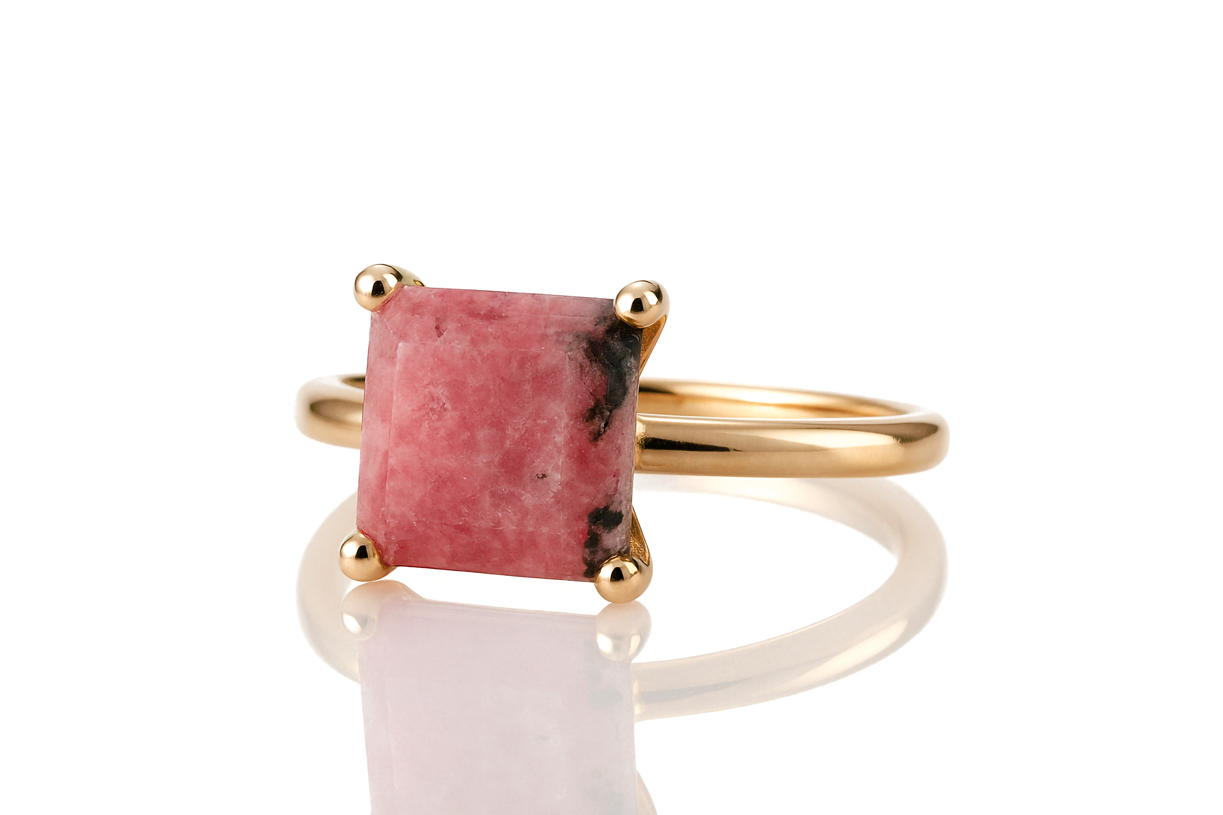 a gold ring with a pink stone in it