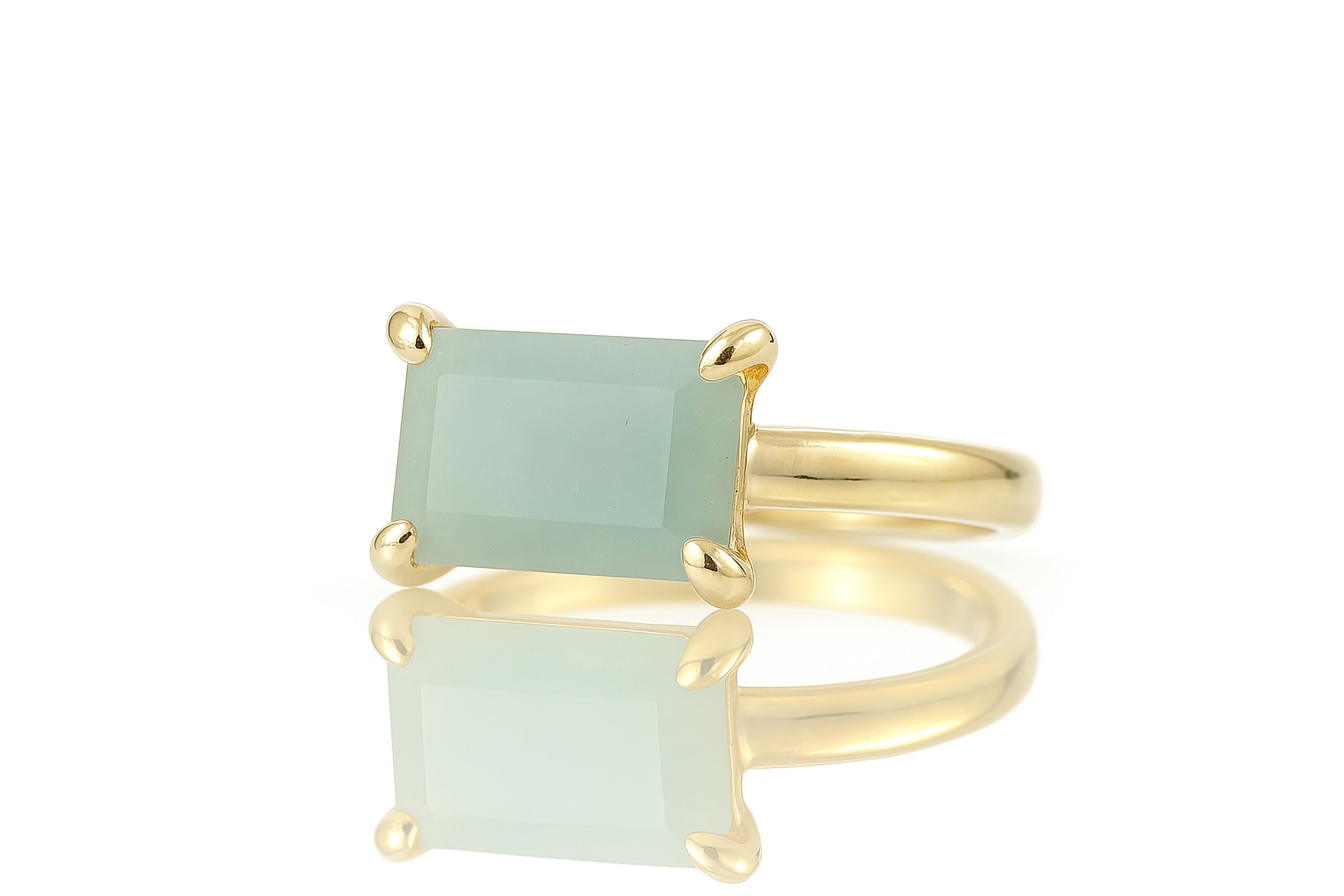 a yellow gold ring with a green stone