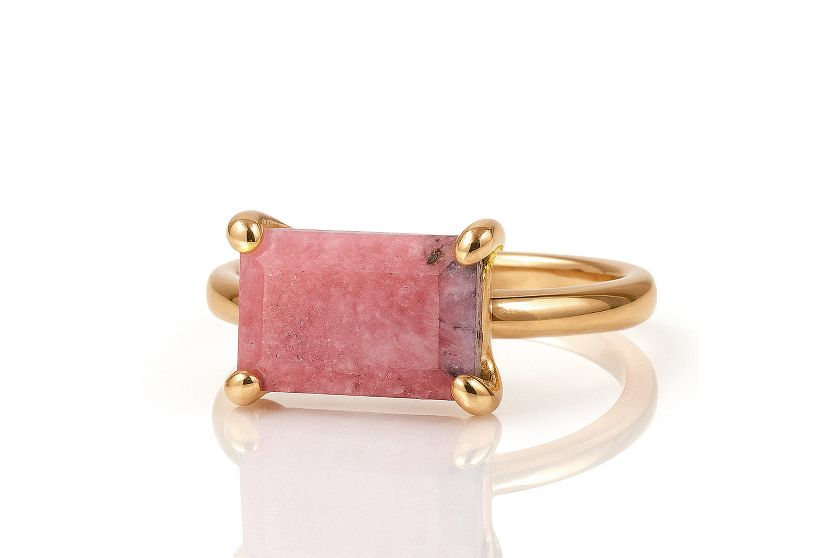 a gold ring with a pink stone on it