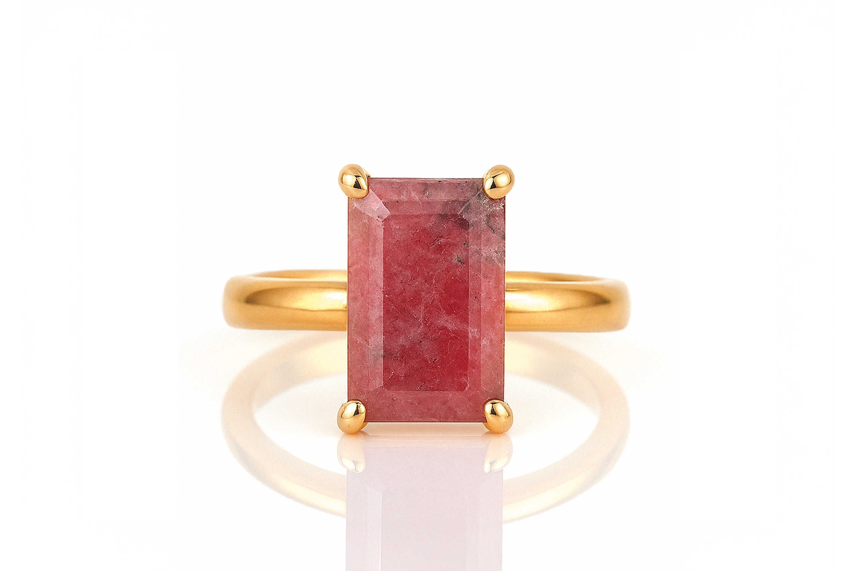 a gold ring with a red stone on it
