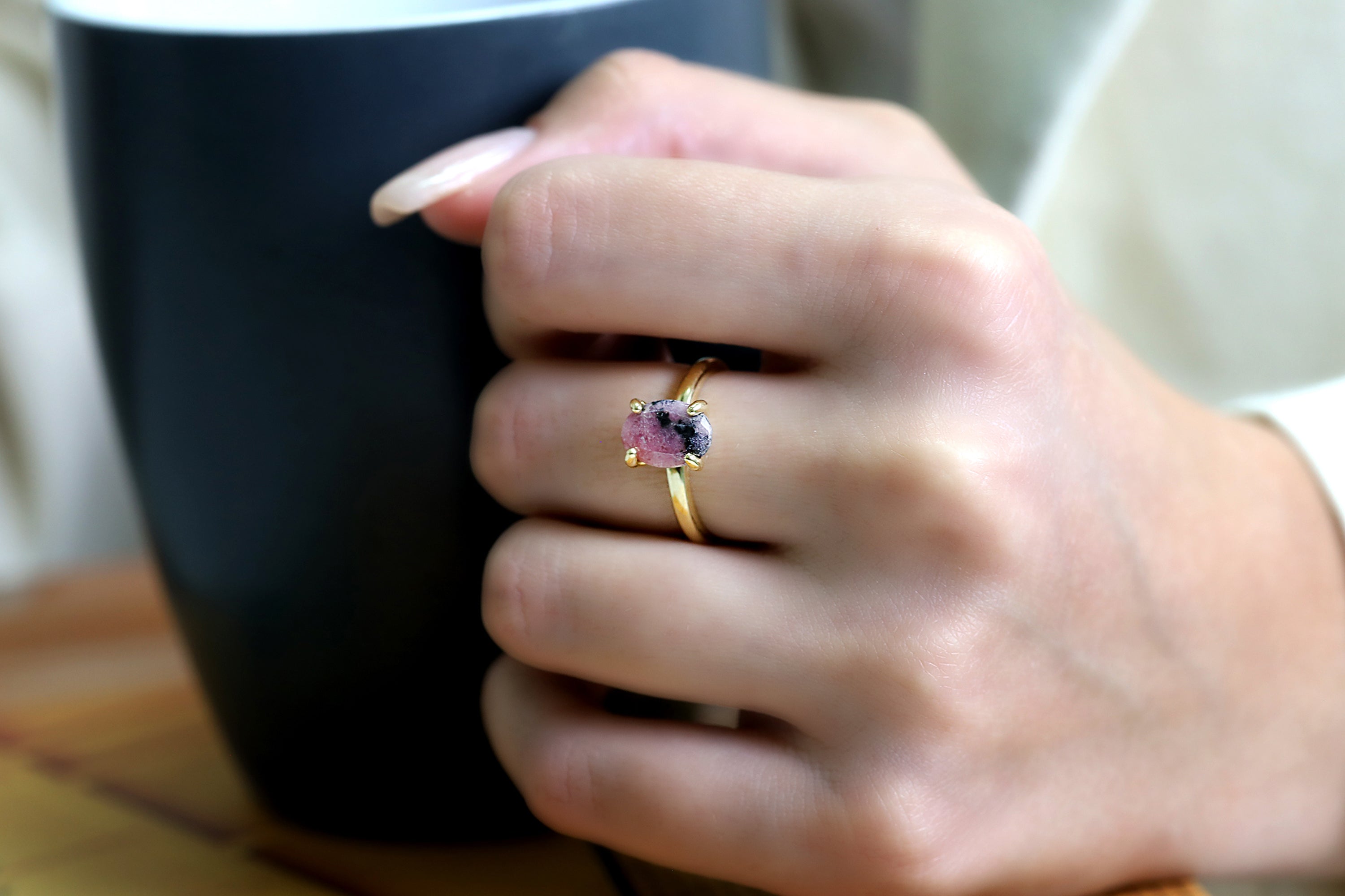 a woman's hand holding a cup of coffee
