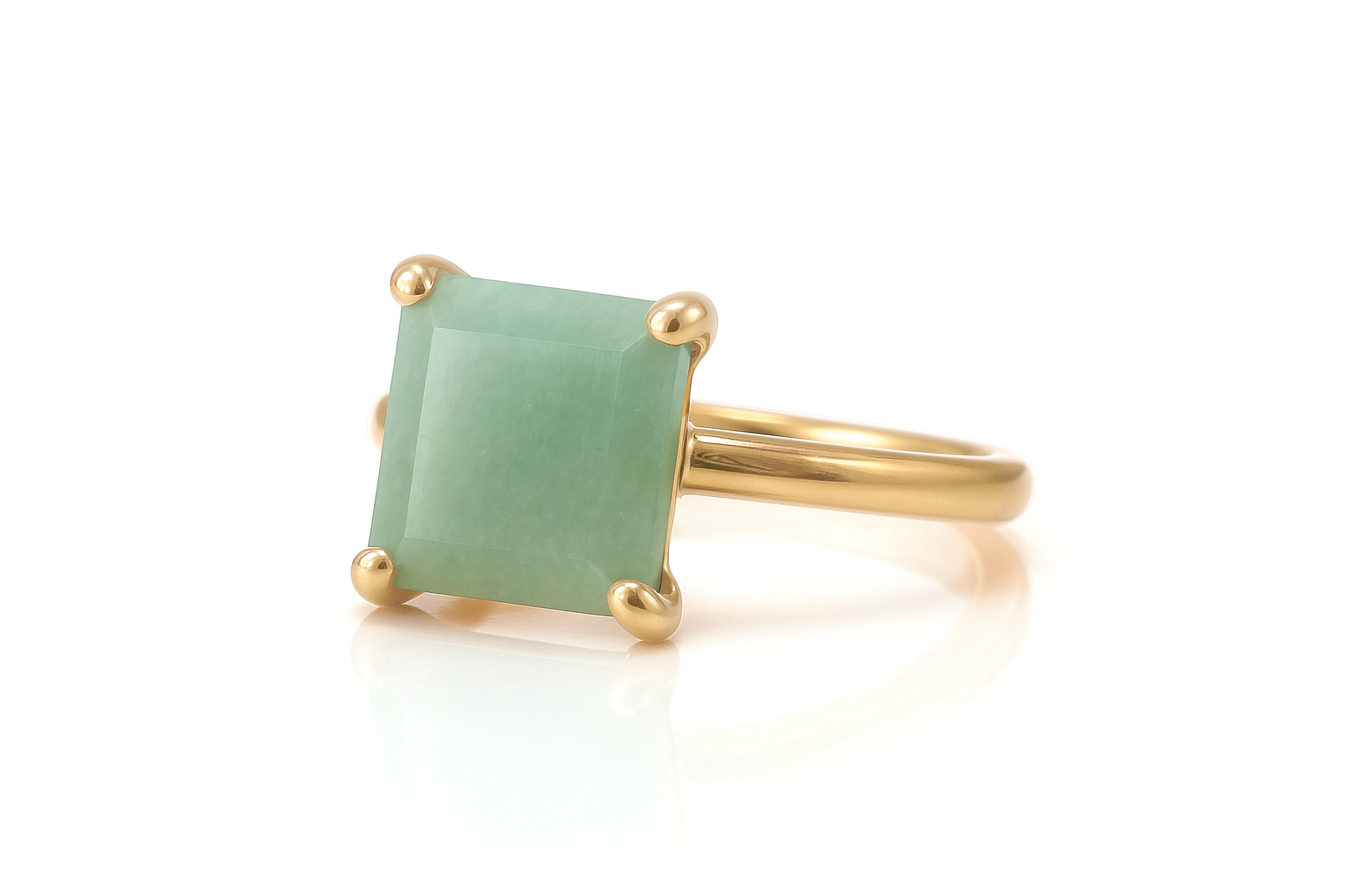 a gold ring with a green stone on it