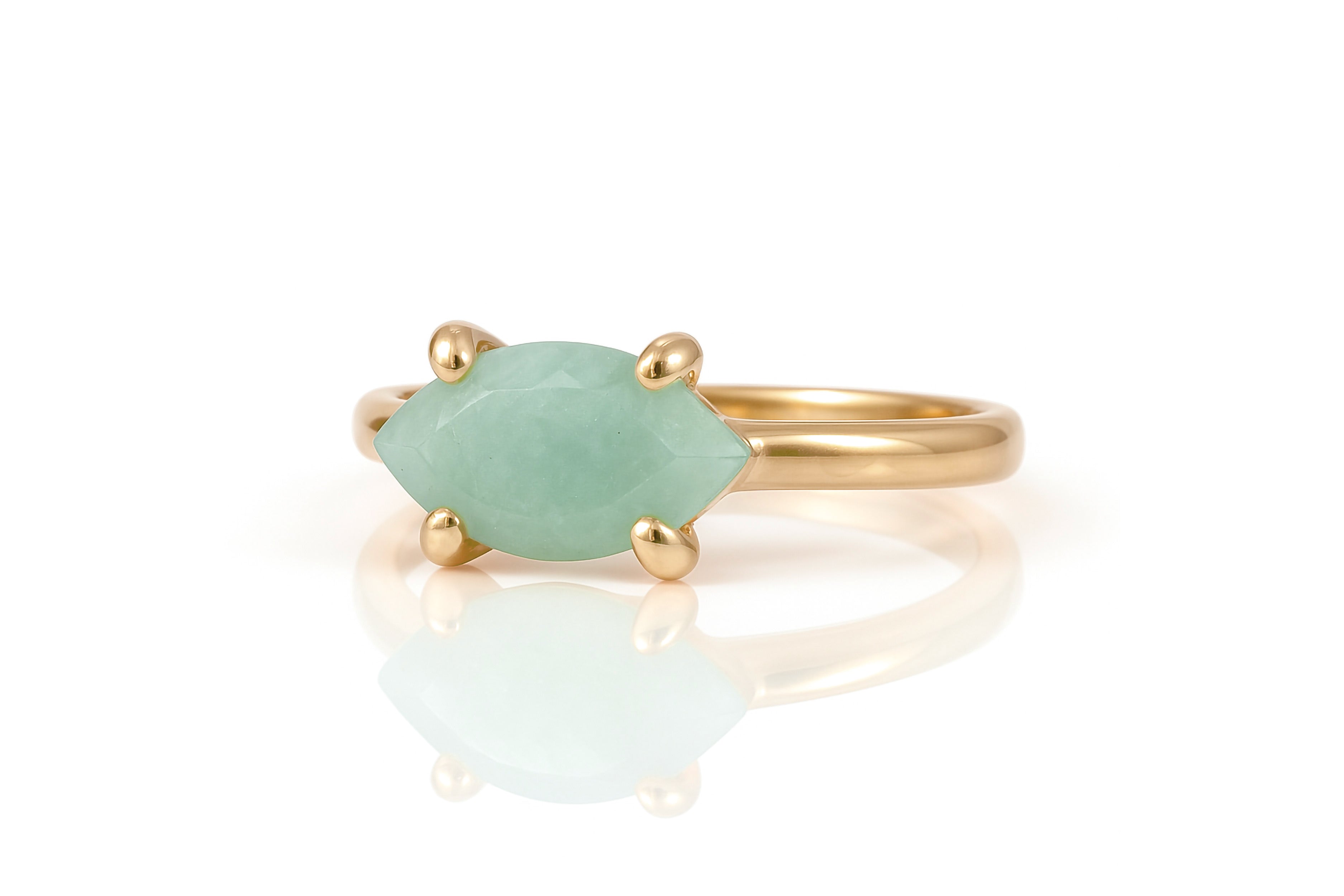a gold ring with a green stone on it