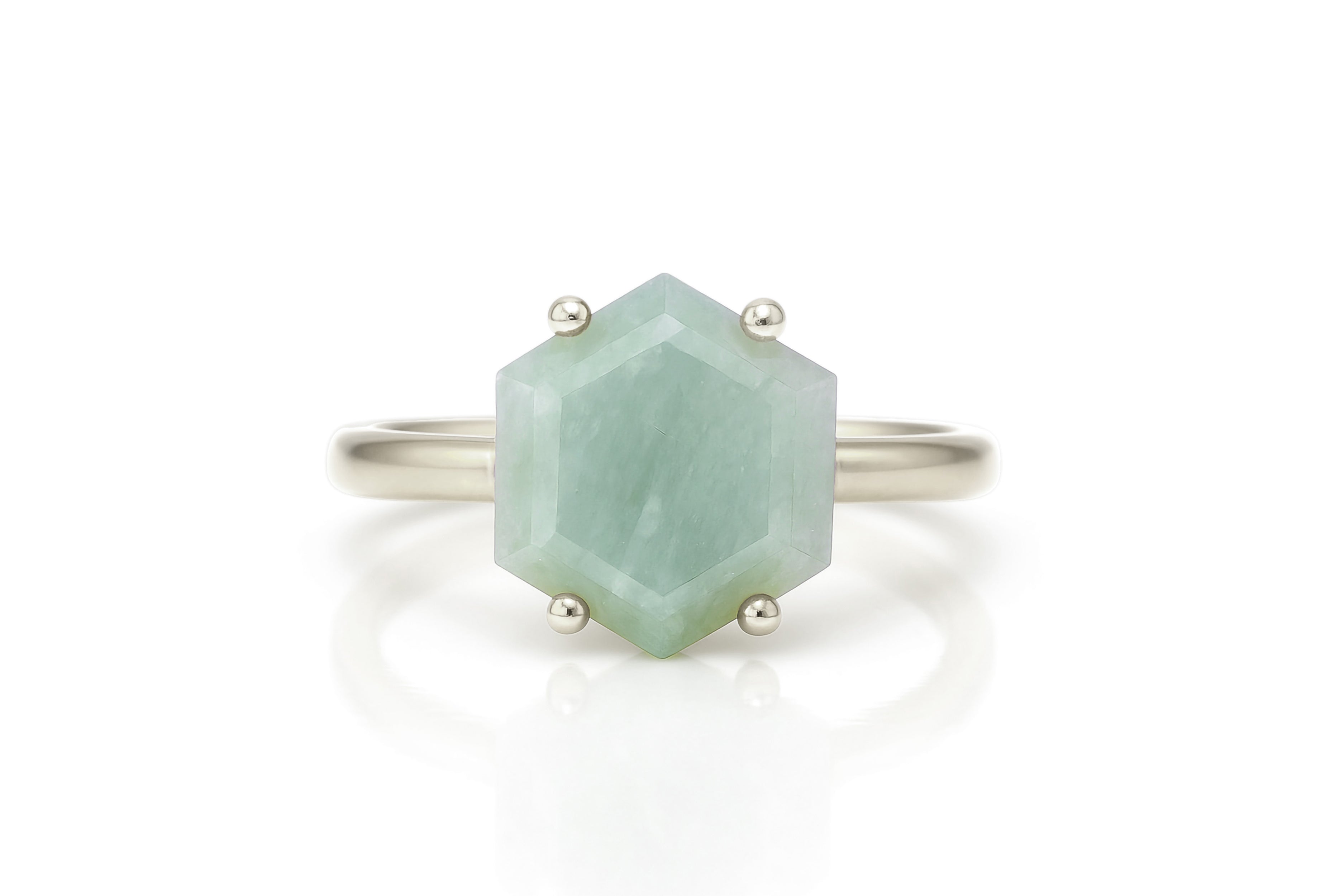 a white gold ring with a green stone