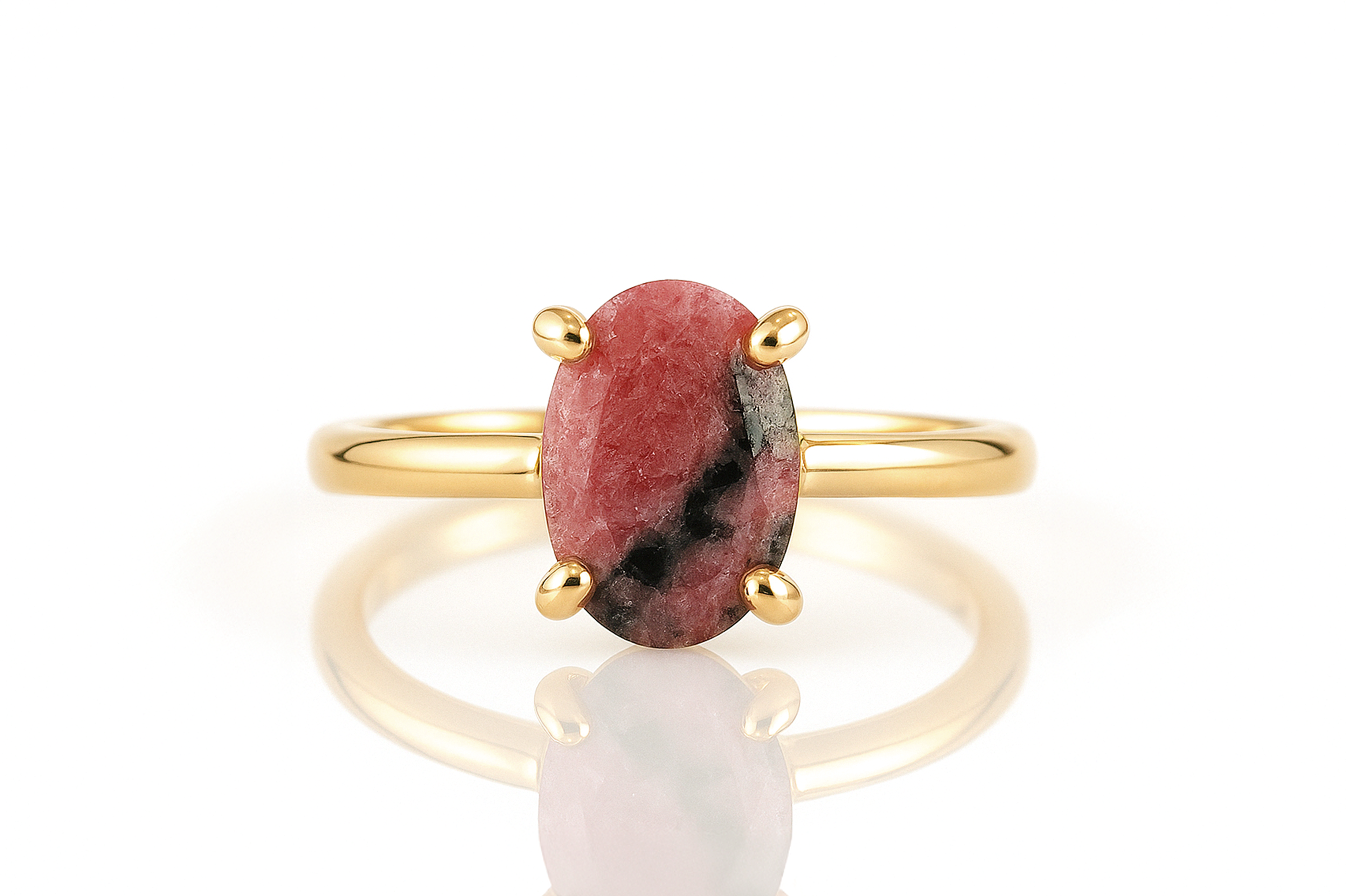 a gold ring with a red stone on it