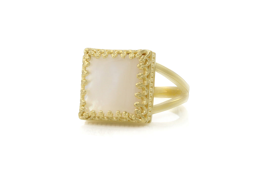 a gold ring with a square shaped white stone